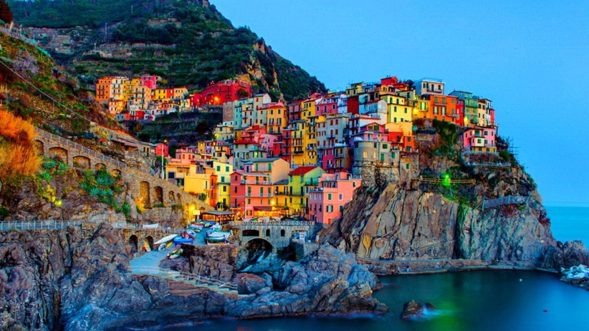 Naples 桌布 壁紙 — 充滿活力的懸崖村莊，在暮色天空和寧靜海面上閃爍著溫暖燈光。