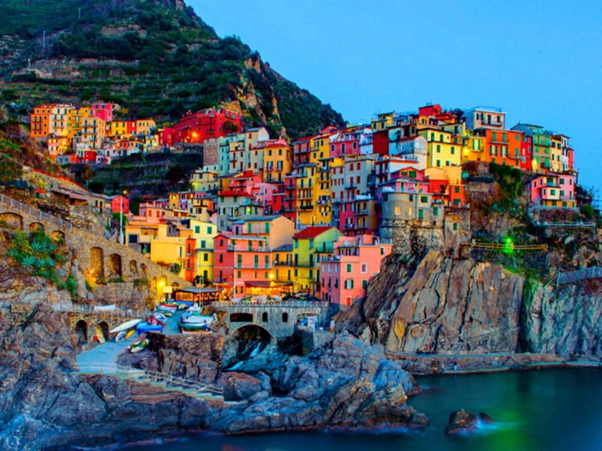 Italy Aesthetic 桌布 壁紙 — 充滿活力的懸崖村莊，溫暖燈光在暮色天空和寧靜海面上閃耀。