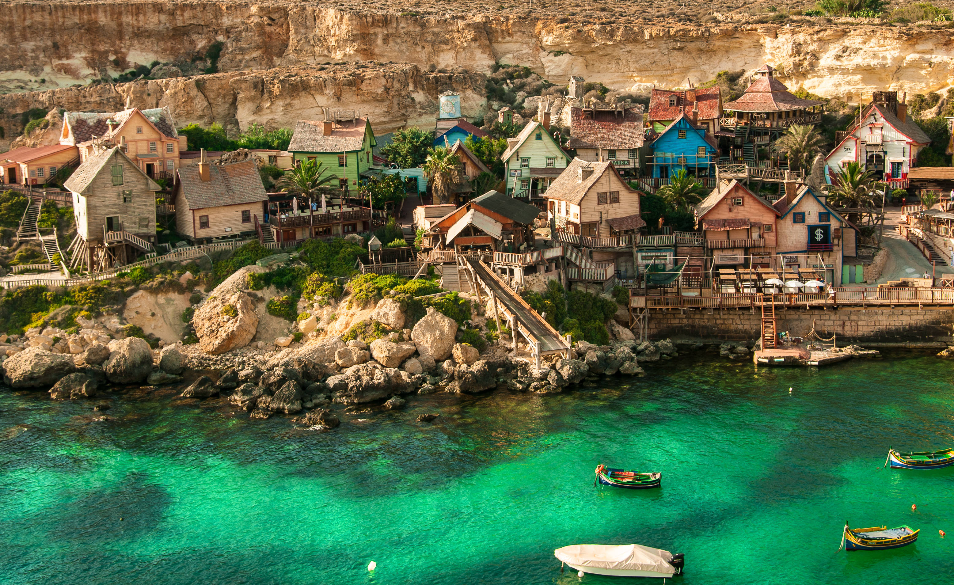 Malta 桌布 壁紙 — 充滿活力的懸崖村莊，色彩繽紛的房屋坐落在碧綠海水之上，點綴著小船。