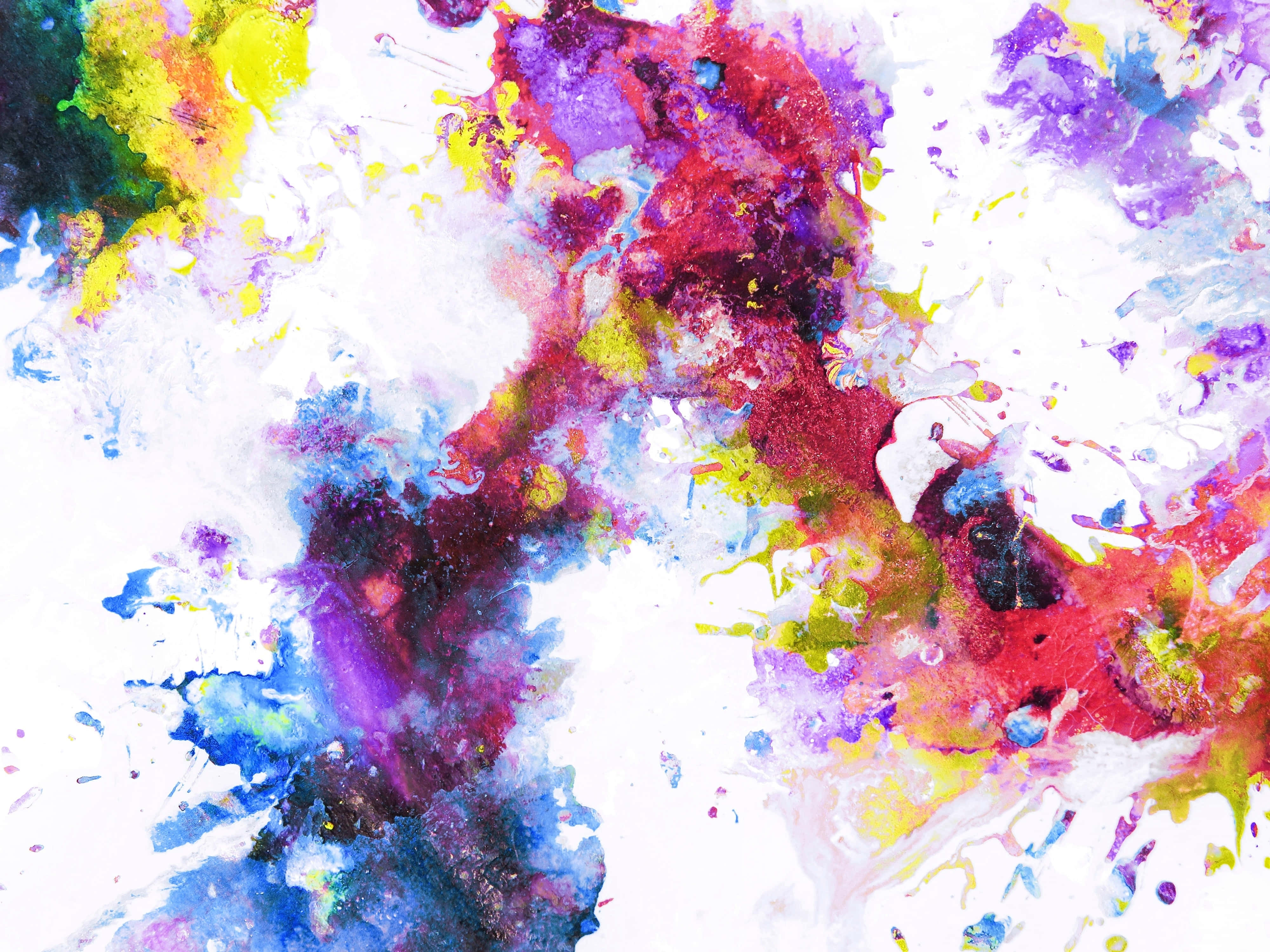 Paint Splash 桌布 壁紙 — 充滿活力的抽象顏料飛濺在明亮的白色畫布上爆炸開來，形成混亂的色彩爆發。