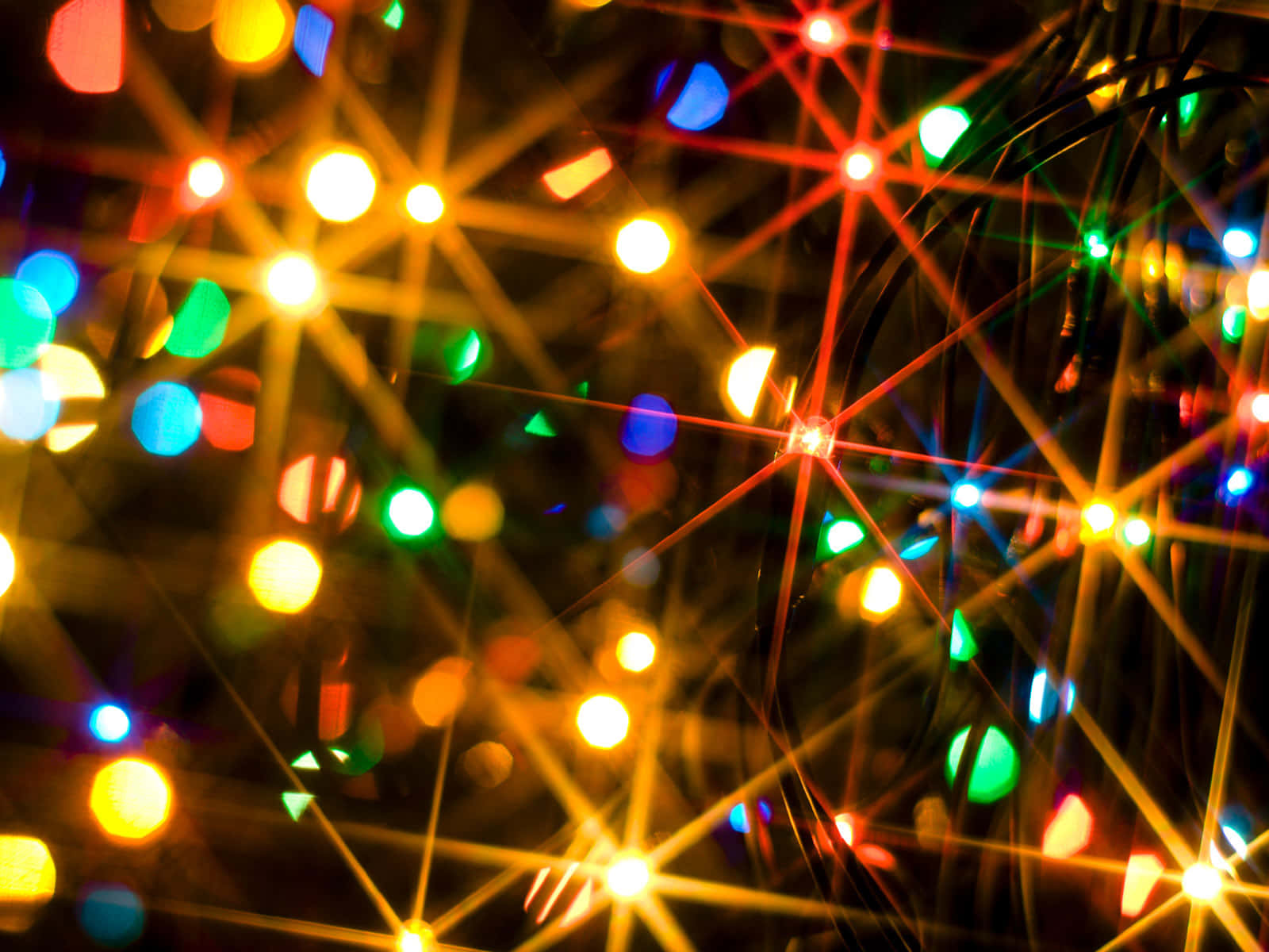 lights 桌布 壁紙 — 充滿活力的散景燈光，紅色、綠色和黃色，在黑暗背景上爆發出星芒。