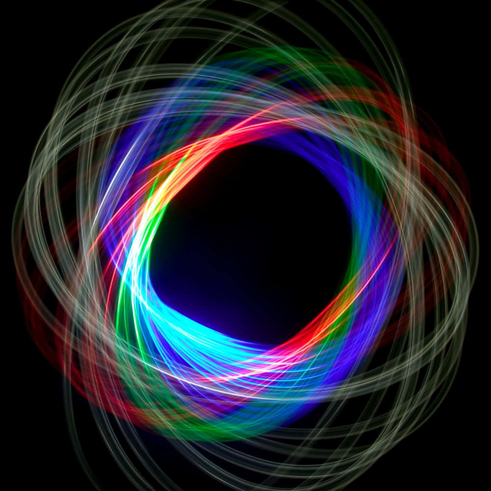 Kinetic Art 桌布 壁紙 — 充滿活力的旋轉光跡，以紅色、藍色和綠色在黑色背景上形成發光的圓形圖案。