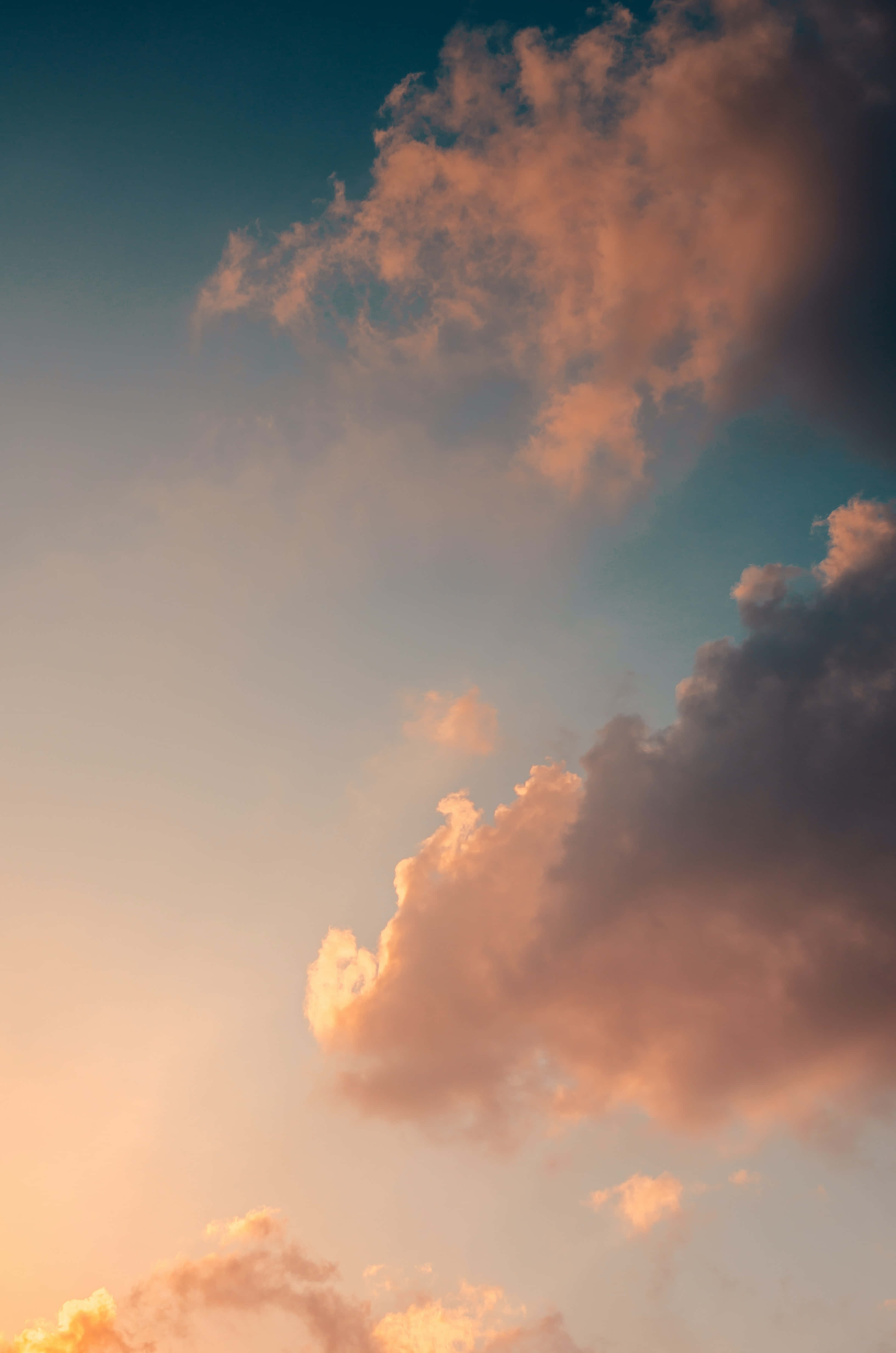 Aesthetic Sky 桌布 壁紙 — 充滿活力的日落雲彩在溫暖的橙色和粉紅色調中發光，映襯著漸深的藍綠色天空。