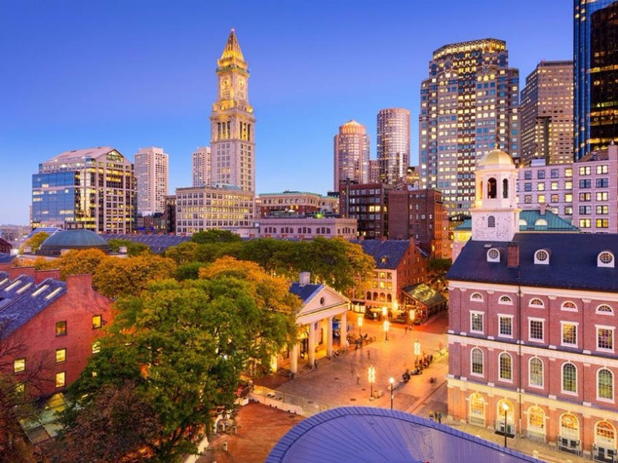 Massachusetts 桌布 壁紙 — 充滿活力的暮色城市景觀，歷史悠久的磚砌建築和現代摩天大樓在深藍色天空的映襯下熠熠生輝。