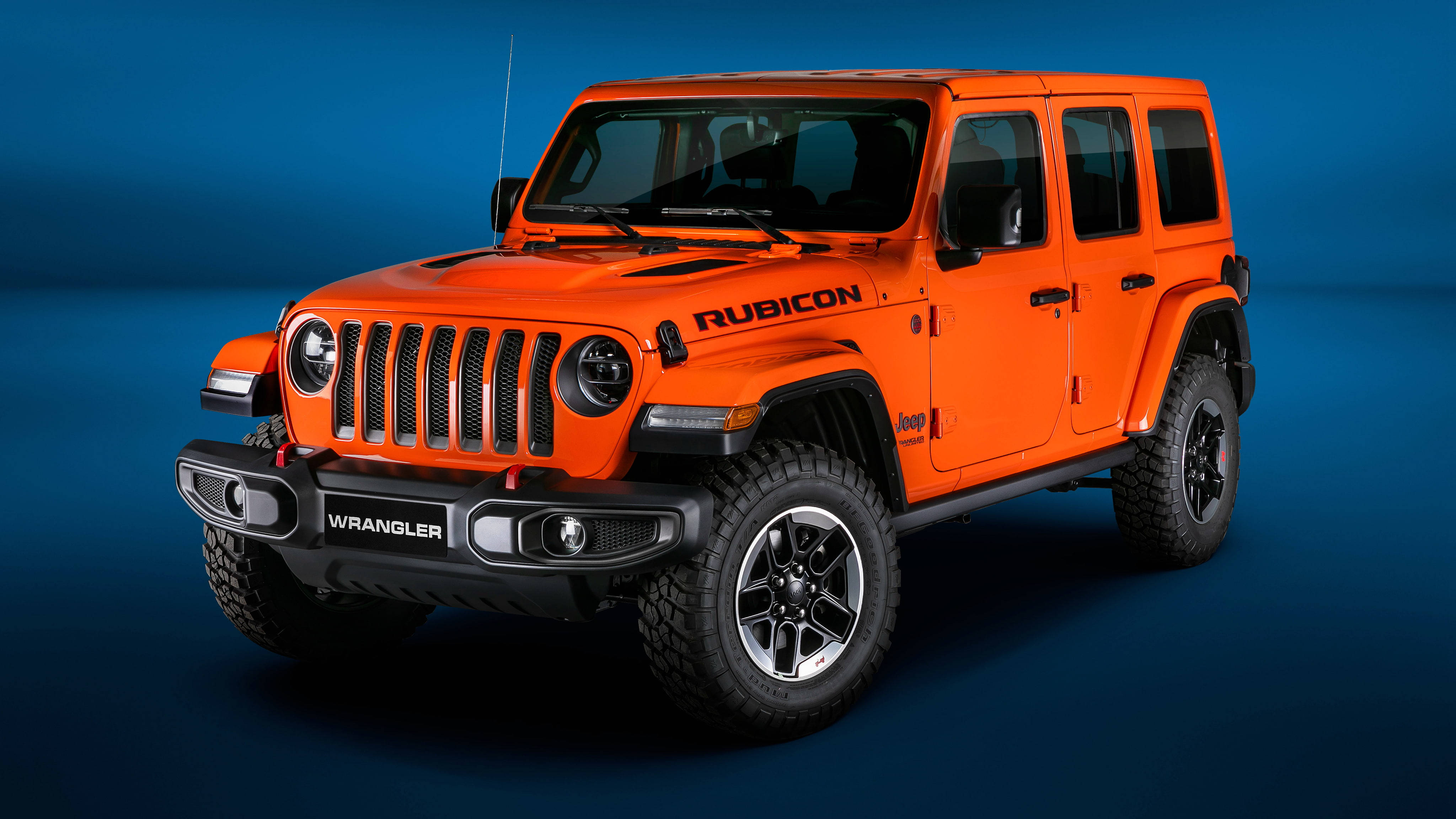 橘色 桌布 壁紙 — 充滿活力的橙色Jeep Wrangler Rubicon在深藍色工作室背景前，搭配戲劇性燈光，大膽地矗立。