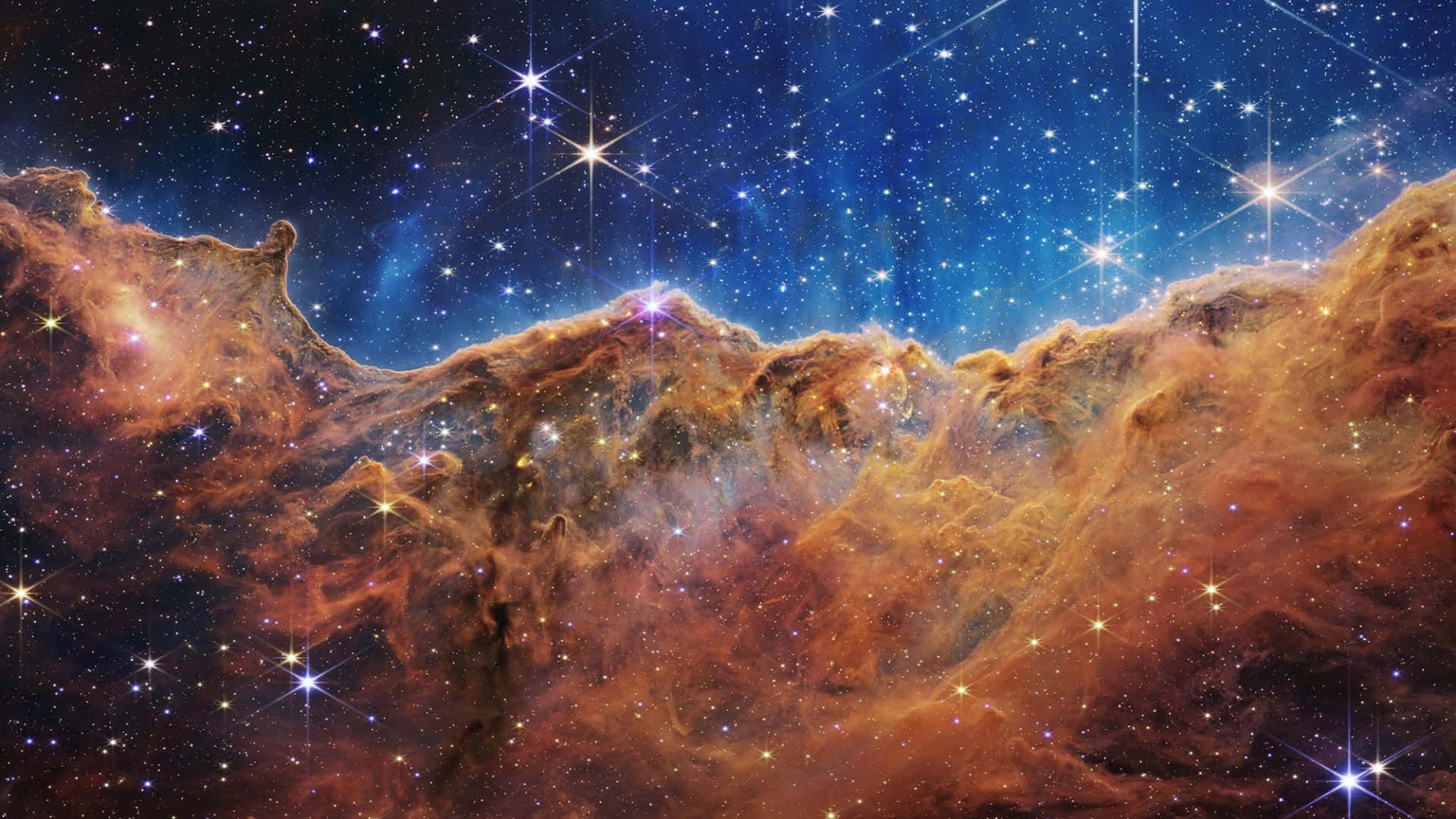 Cosmic Dust 桌布 壁紙 — 充滿活力的橙色和藍色宇宙雲層在令人嘆為觀止的深空景觀中與閃爍的星星旋轉。