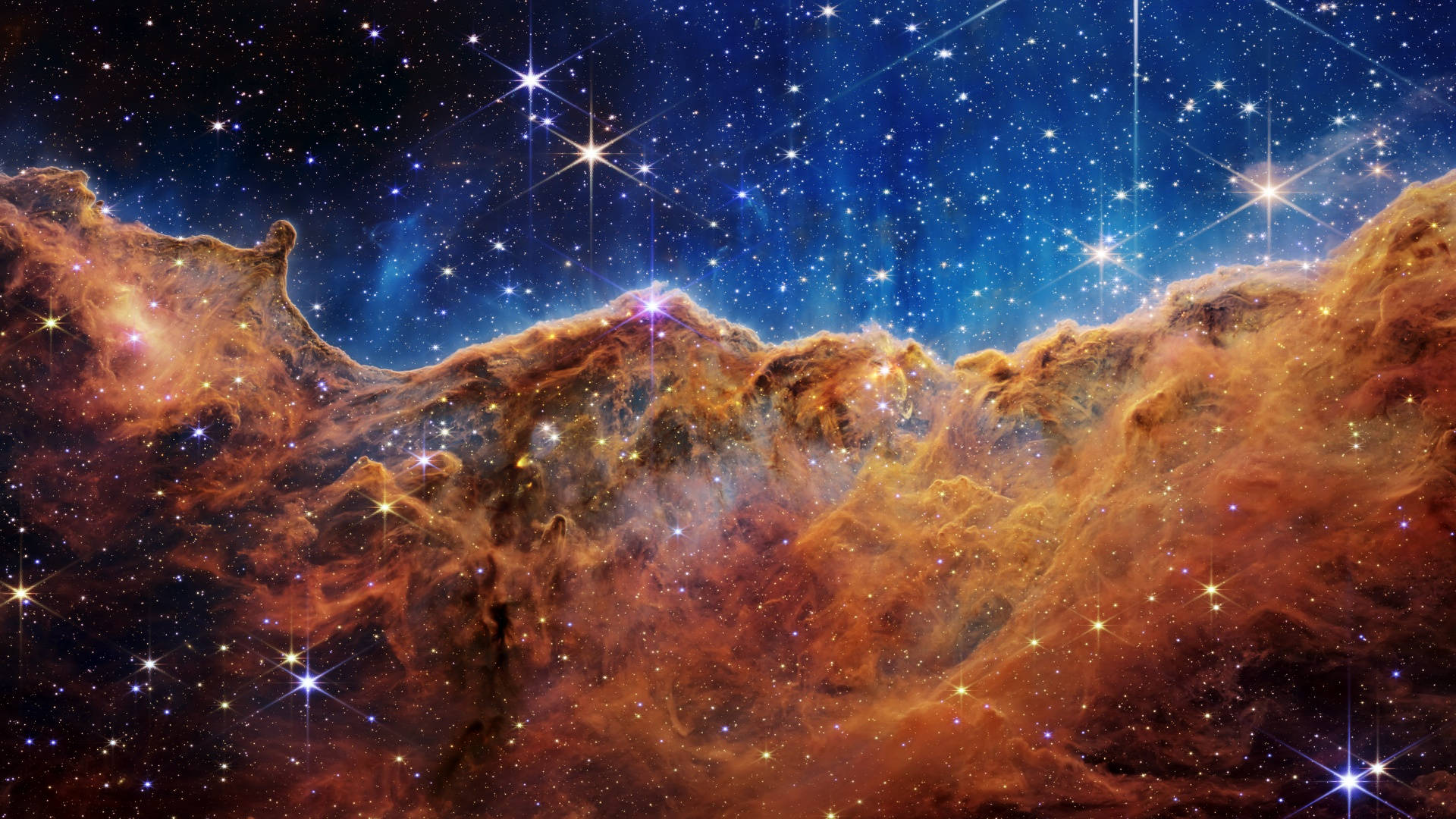 宇宙美學 桌布 壁紙 — 充滿活力的橙色和藍色宇宙雲層與閃爍的星星在令人嘆為觀止的深空景觀中旋轉。