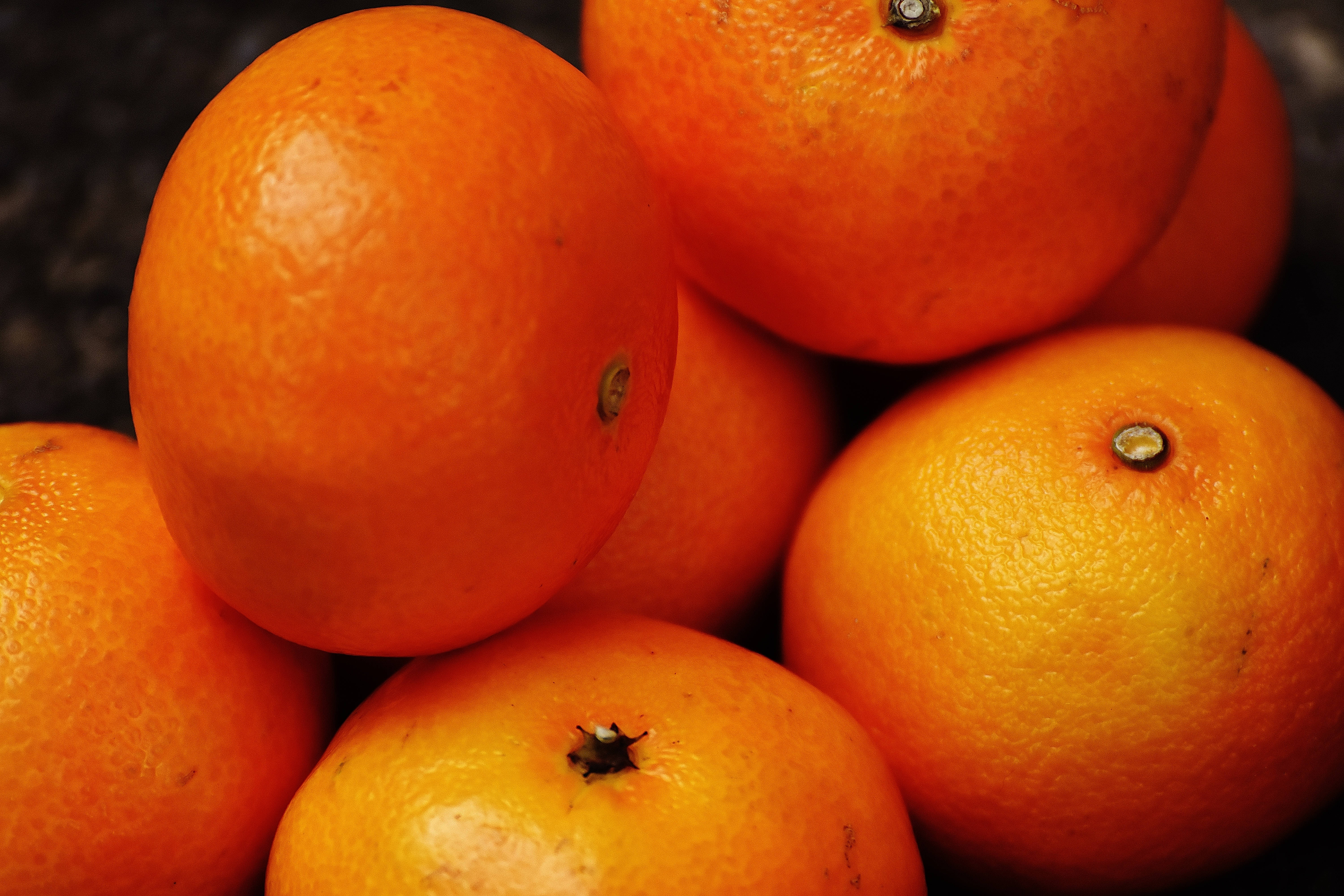 Fruits 桌布 壁紙 — 充滿活力的橙色柑橘類水果特寫，帶有紋理果皮和可見的莖。