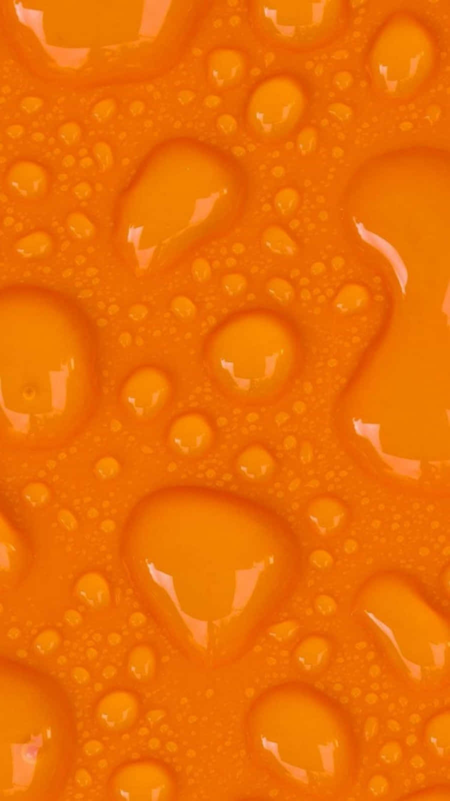 Cute Orange 桌布 壁紙 — 充滿活力的橙色液體滴在紋理表面上閃爍著光芒，形成光澤的抽象圖案。