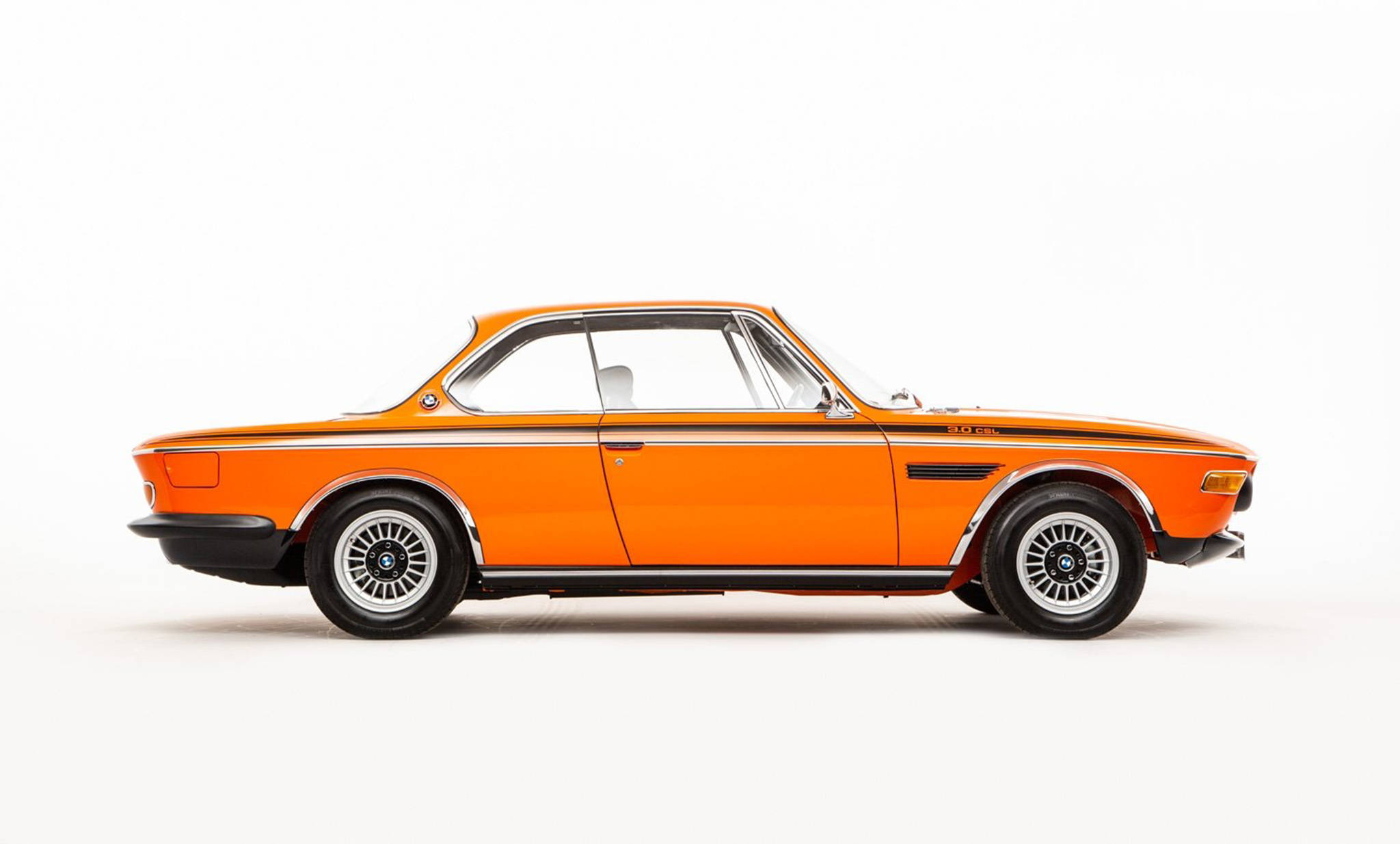 classic bmw 桌布 壁紙 — 充滿活力的橙色經典BMW 3.0 CSL雙門轎跑車，在乾淨的白色工作室背景下展示完整側面輪廓。