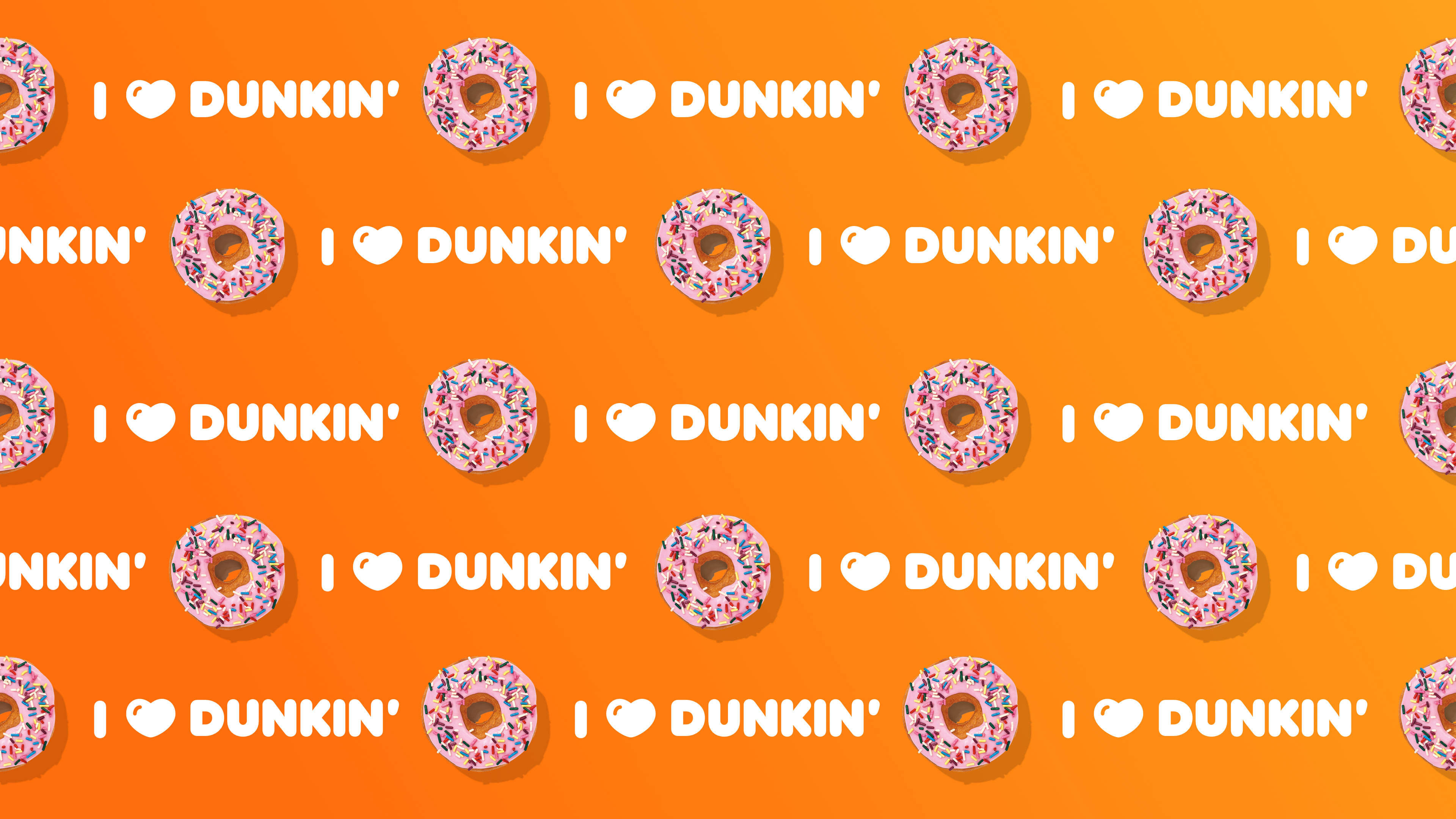 donuts 桌布 壁紙 — 充滿活力的橙色背景，重複排列粉紅色糖霜甜甜圈和白色「I ❤️ DUNKIN」文字。