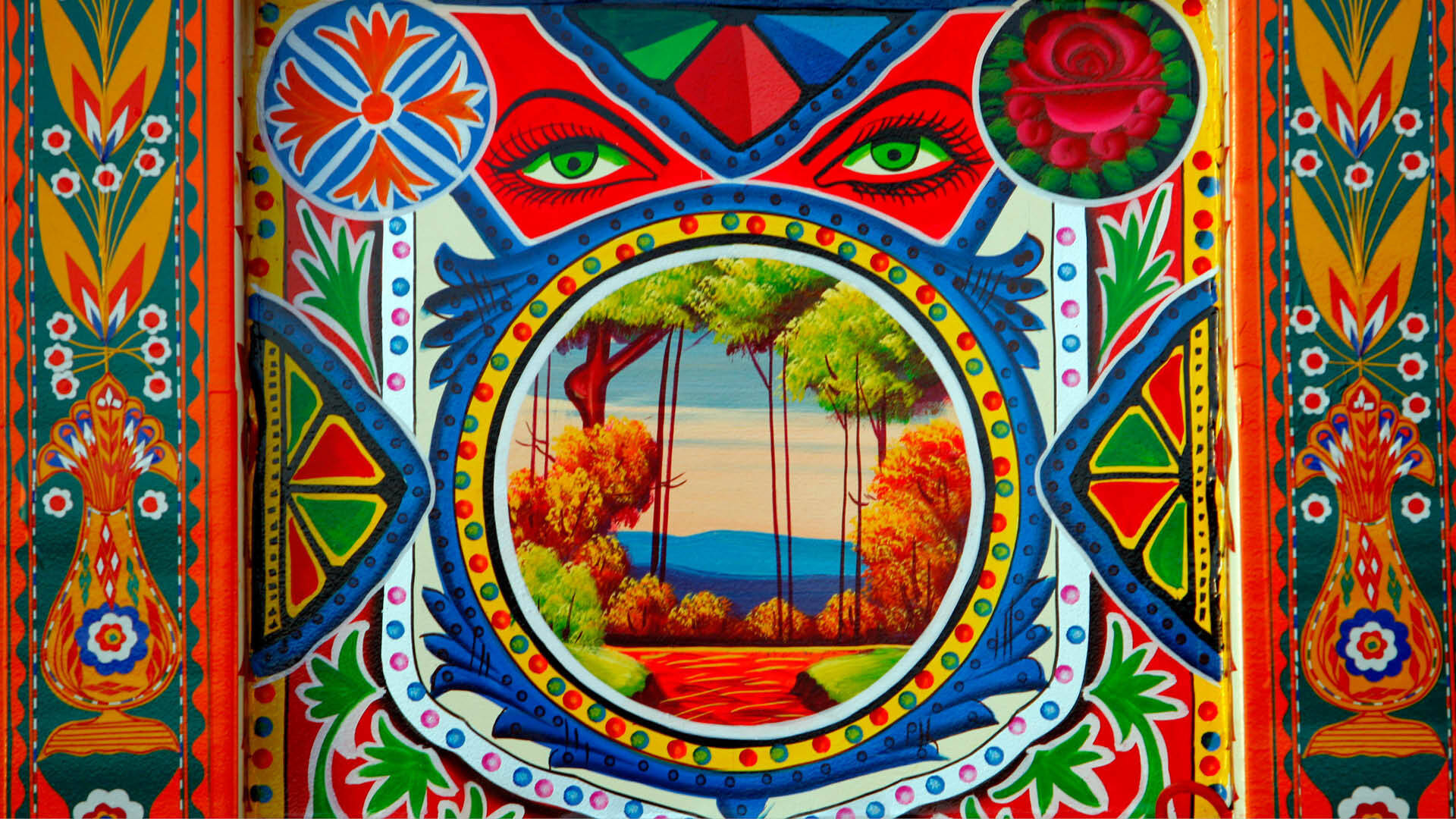 Folk Art 桌布 壁紙 — 充滿活力的民間藝術面板，以圓形秋日森林場景為特色，周圍環繞著大膽的幾何圖案和風格化的綠色眼睛。