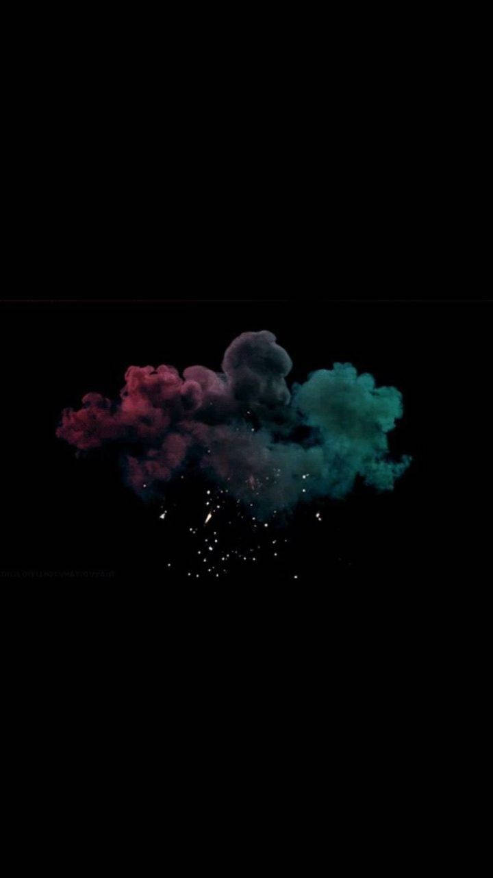 Dark Theme iPhone 桌布 壁紙 — 充滿活力的洋紅色和藍綠色粉末雲在純黑色背景上爆炸，帶有閃爍的顆粒。