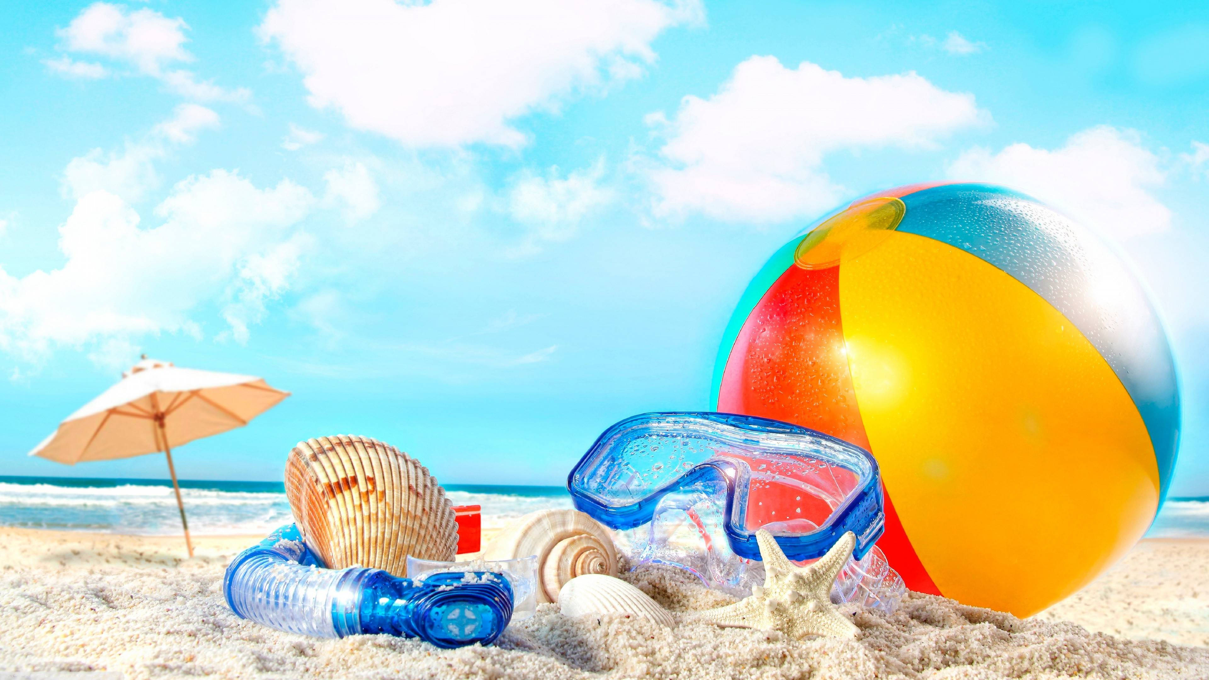 夏天 桌布 壁紙 — 充滿活力的海灘場景，色彩繽紛的球、潛水裝備和貝殼在金色沙灘上，藍天白雲。