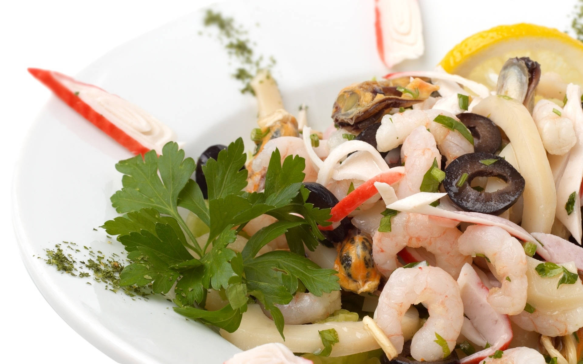 shrimp 桌布 壁紙 — 充滿活力的海鮮沙拉，有蝦、淡菜、蟹肉棒、橄欖和巴西里，配上檸檬，放在白色盤子上。