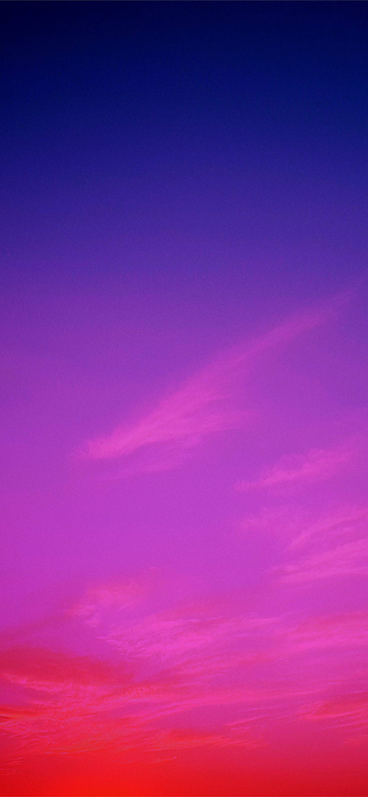iPhone 11 Purple 桌布 壁紙 — 充滿活力的漸變天空從深藍色過渡到電光粉紅和火紅色，帶有縷縷薄雲。