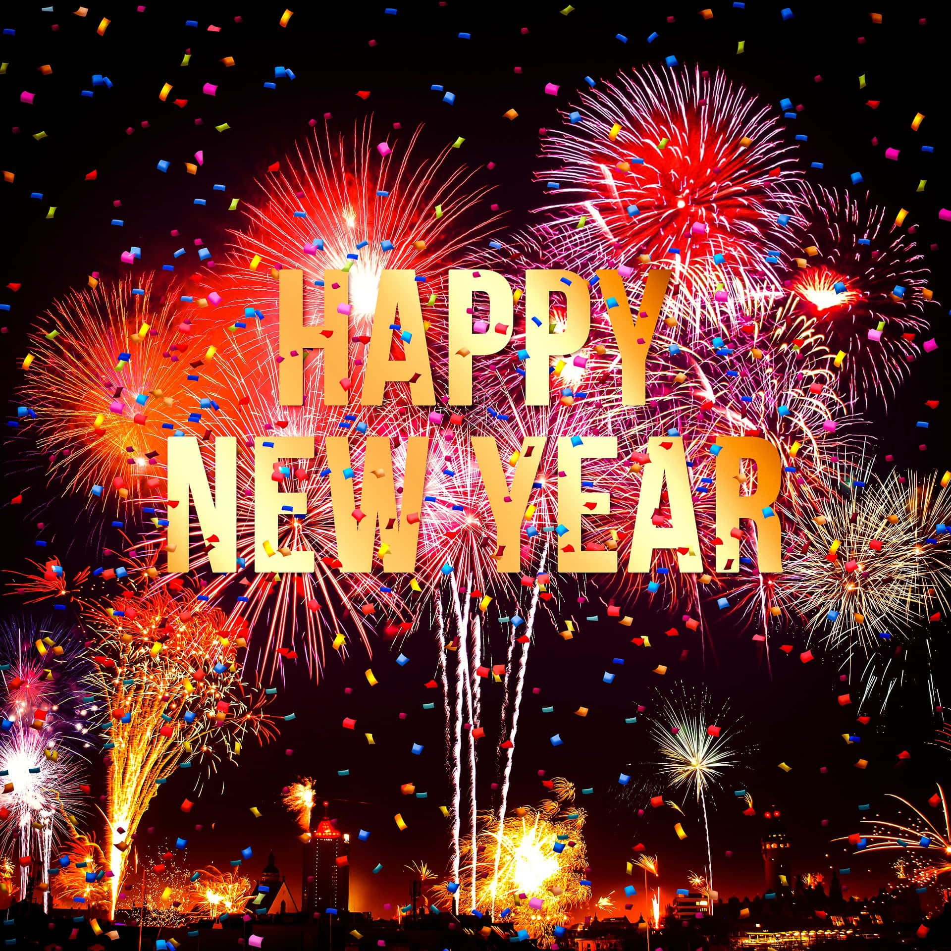 新年 桌布 壁紙 — 充滿活力的煙火在城市天際線上綻放，五彩紙屑在粗體金色「新年快樂」文字周圍飄落。