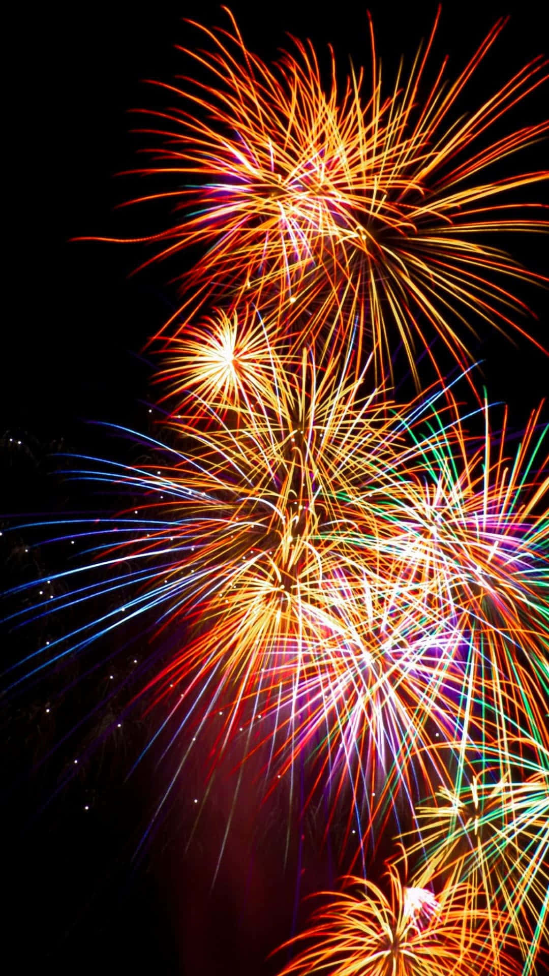 Fireworks 桌布 壁紙 — 充滿活力的煙火在漆黑的夜空中綻放出橙色、藍色和綠色的燦爛光芒。