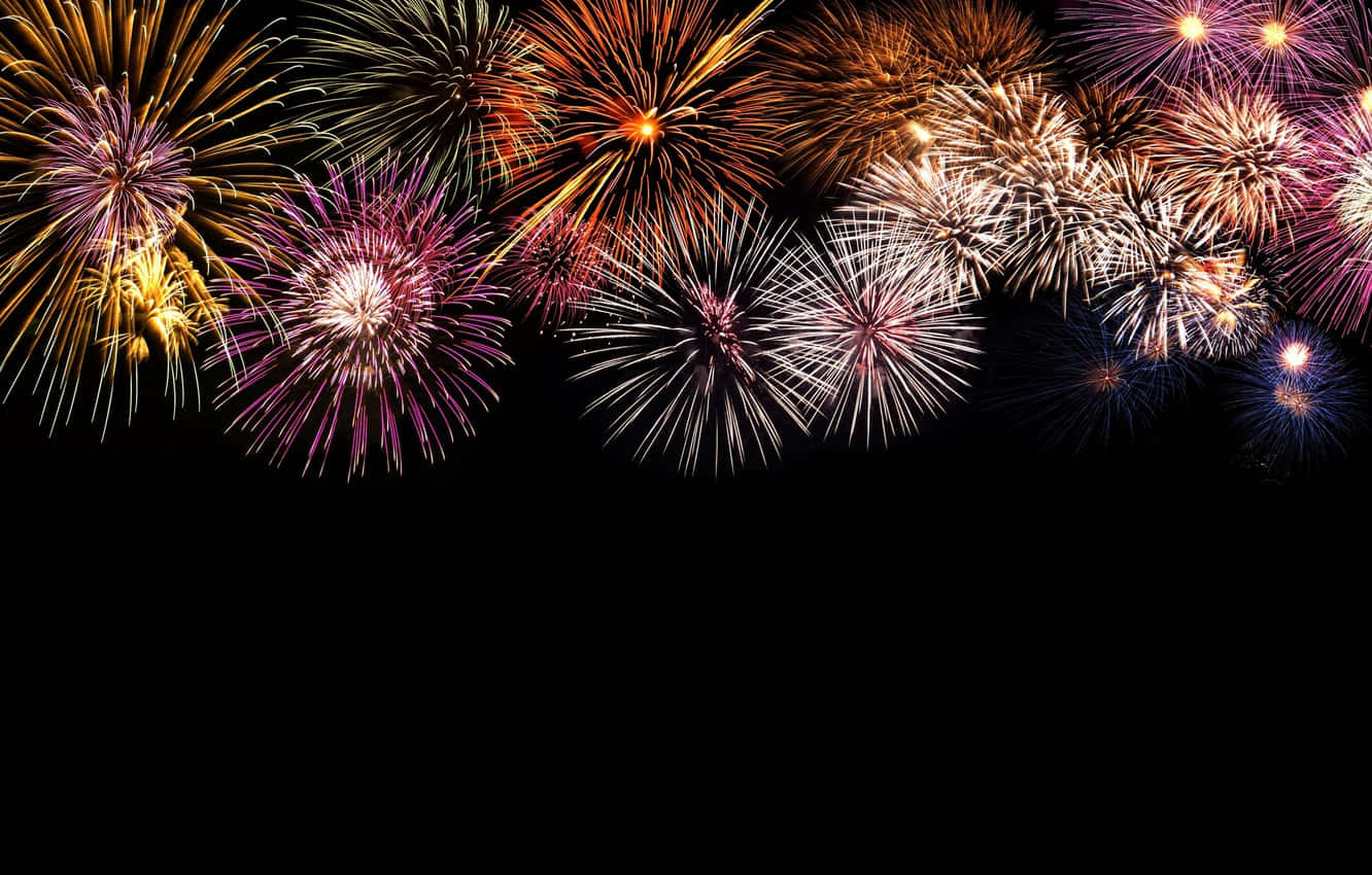 Fireworks 桌布 壁紙 — 充滿活力的煙火在漆黑的夜空中綻放出金色、紫色和白色的耀眼色彩。