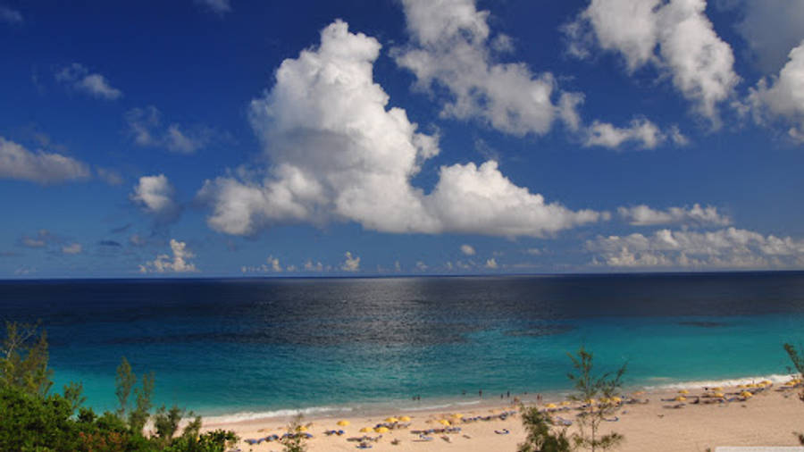Bermuda 桌布 壁紙 — 充滿活力的熱帶海灘，碧綠的海水和蓬鬆的白雲，在深藍色的天空下。