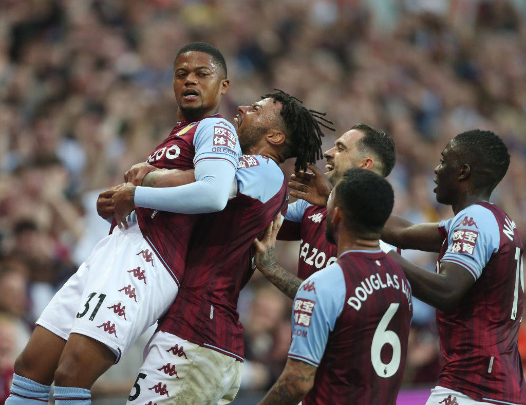 Aston Villa 桌布 壁紙 — 充滿活力的球場場景捕捉到身穿酒紅色和淺藍色球衣的阿斯頓維拉球員，以強烈的情感和身體擁抱慶祝進球。