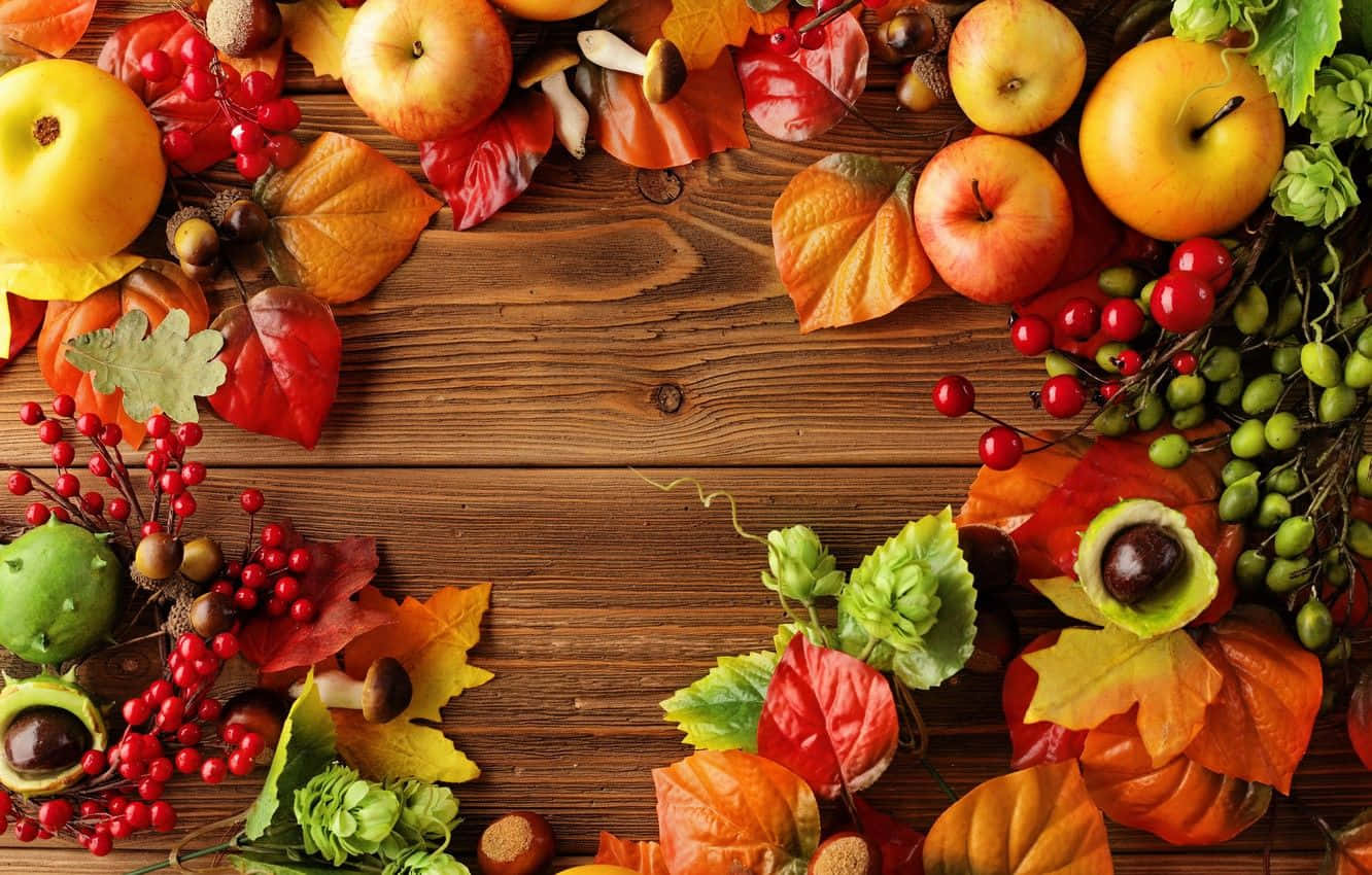 Fall Apples 桌布 壁紙 — 充滿活力的秋葉、蘋果和漿果，以溫暖的季節色彩環繞質樸的木質表面。