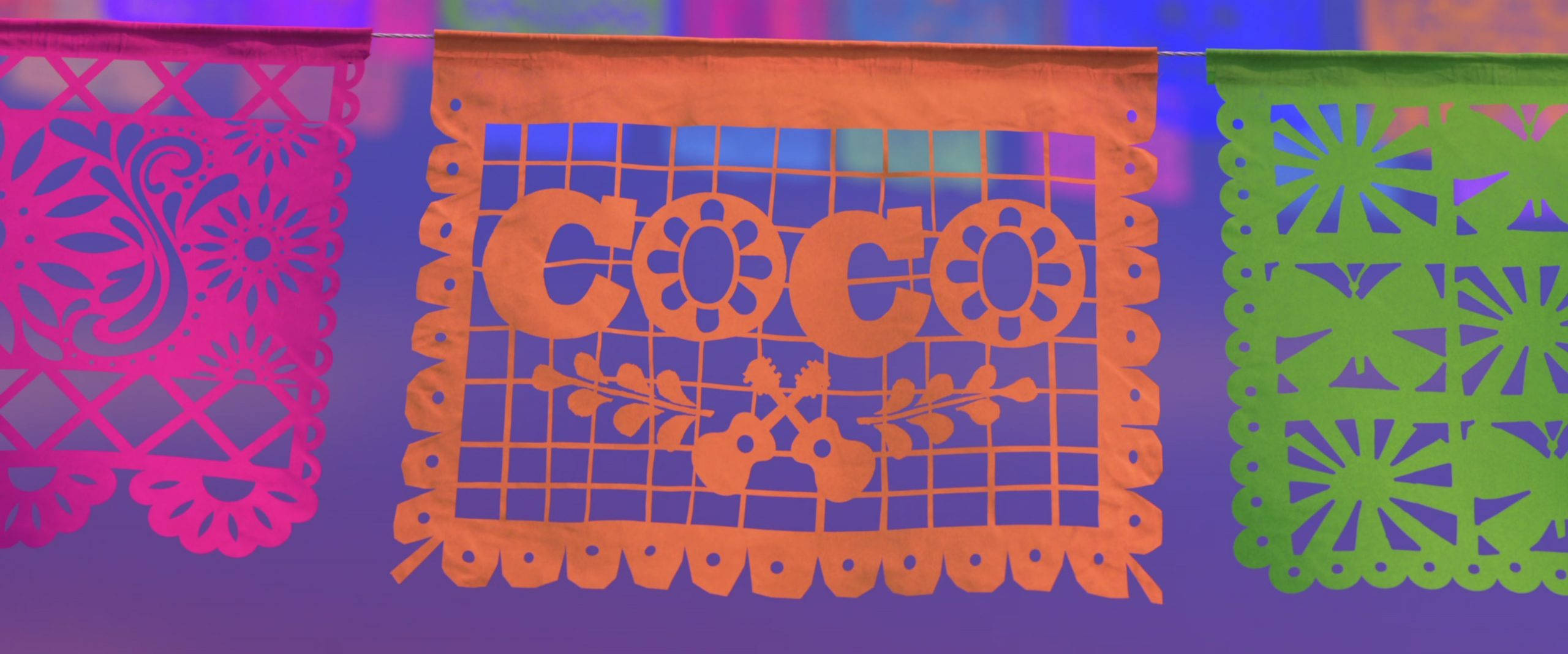 可可 桌布 壁紙 — 充滿活力的粉紅色、橙色和綠色 papel picado 橫幅掛在紫色背景上，帶有 'COCO' 和吉他鏤空圖案。