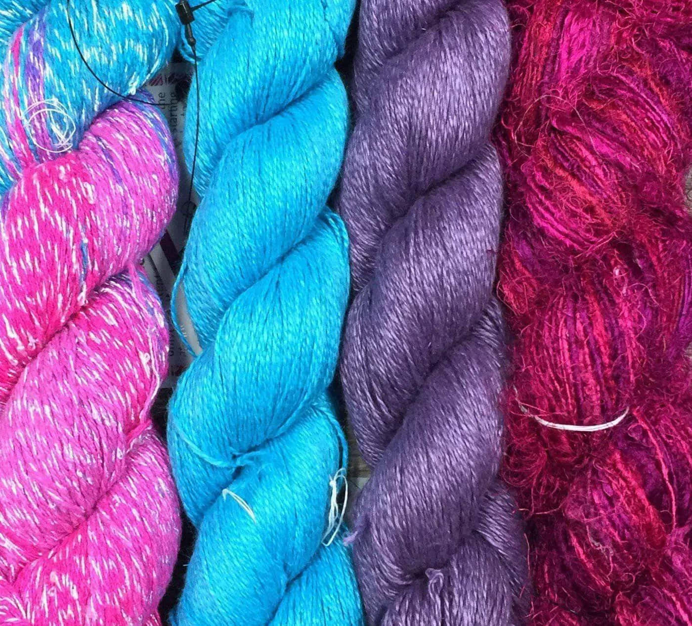 Knitting 桌布 壁紙 — 充滿活力的粉紅色、藍綠色和紫色調的紗線，扭成粗辮子。