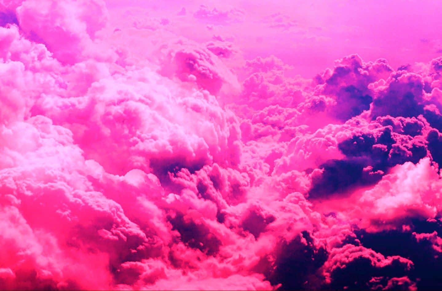 Pink Cloud 桌布 壁紙 — 充滿活力的粉紅色和洋紅色雲朵在超現實的天空中旋轉，帶有深紫色的陰影。