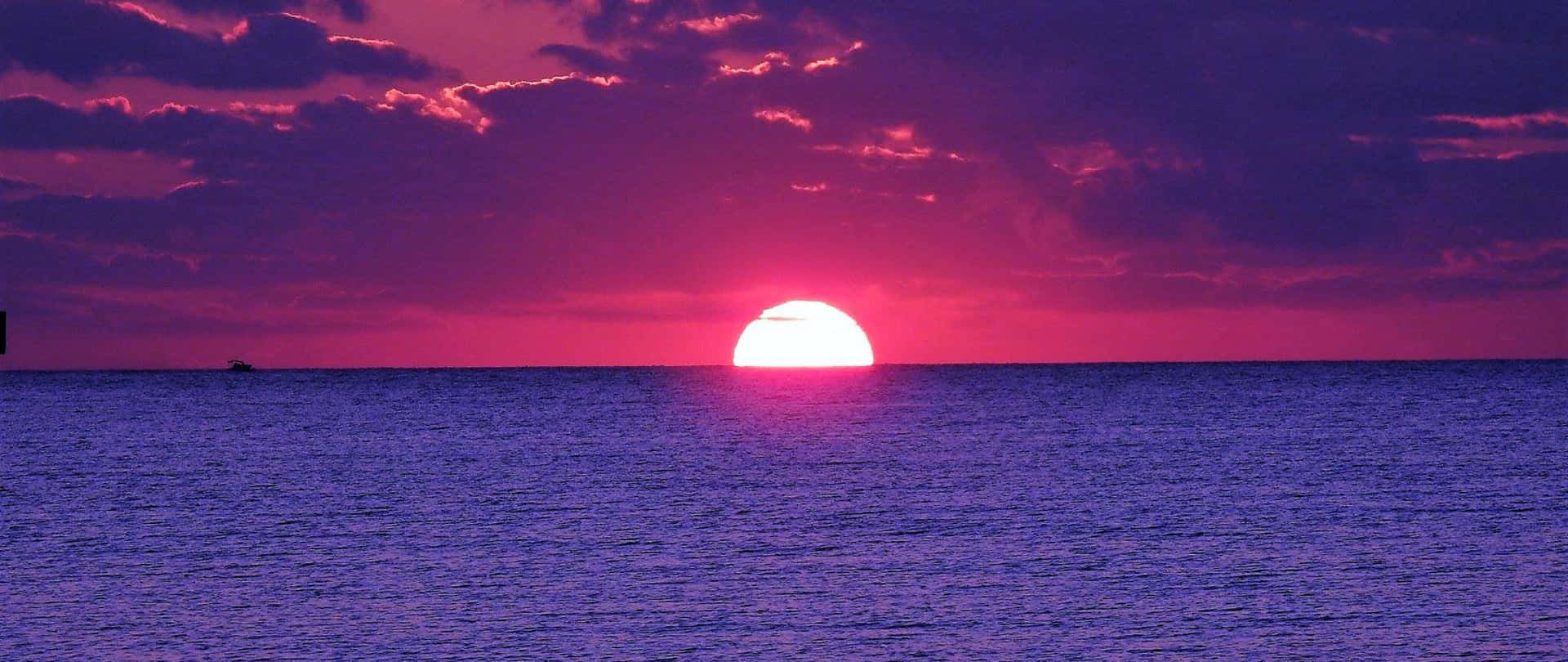 充滿活力的粉紅色和紫色日落，平靜的海洋，小船剪影。 — 2560x1080 動態桌布 壁紙