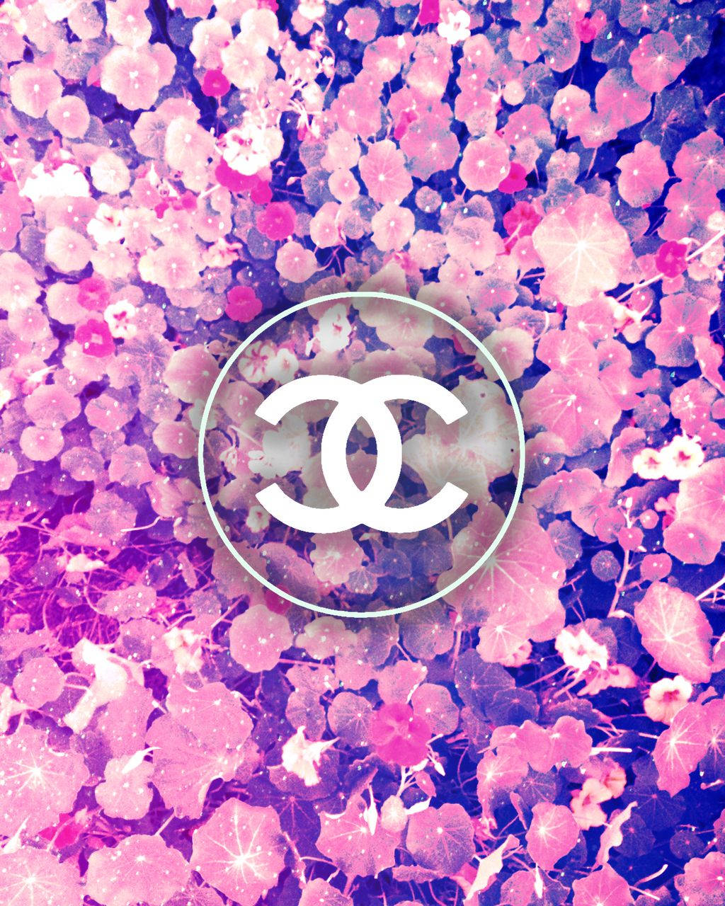 Pink Chanel Logo 桌布 壁紙 — 充滿活力的粉紅色和紫色花卉背景，白色Chanel標誌置中於圓形內。