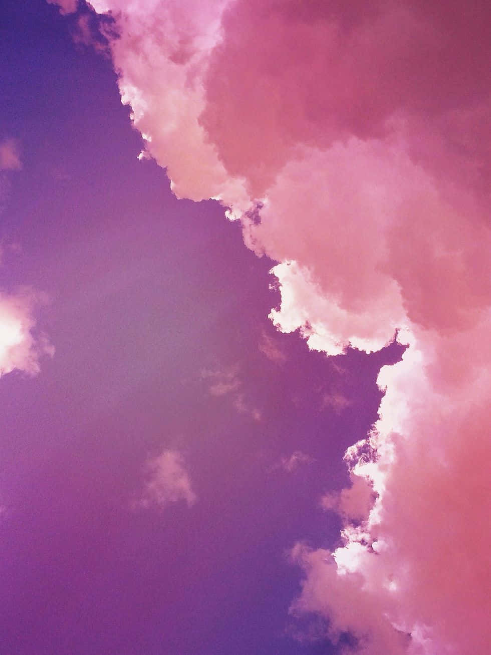 桌布 壁紙 — 充滿活力的粉紅色和紫色雲朵在夢幻般的暮色天空中飄移，邊緣柔和發光。