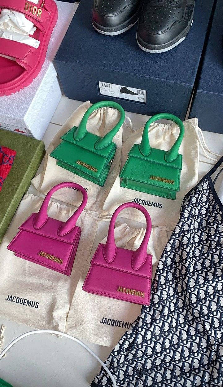 Handbag 桌布 壁紙 — 充滿活力的粉紅色和綠色迷你手提包放在品牌防塵袋上，旁邊是豪華鞋子和圖案服裝。