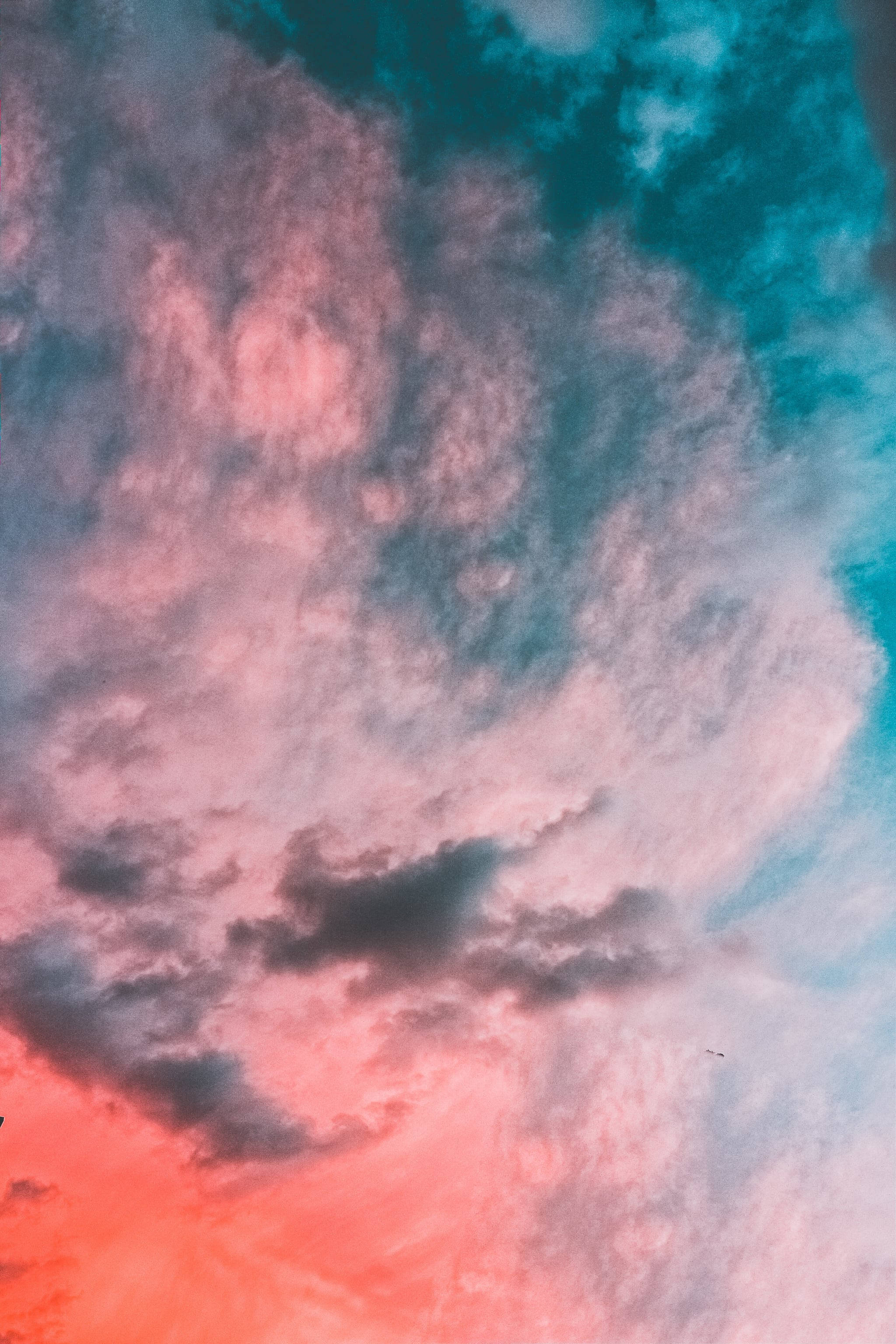 iOS 14 桌布 壁紙 — 充滿活力的粉紅色和藍綠色雲彩在暮色天空中戲劇性地旋轉，帶有深色陰影。