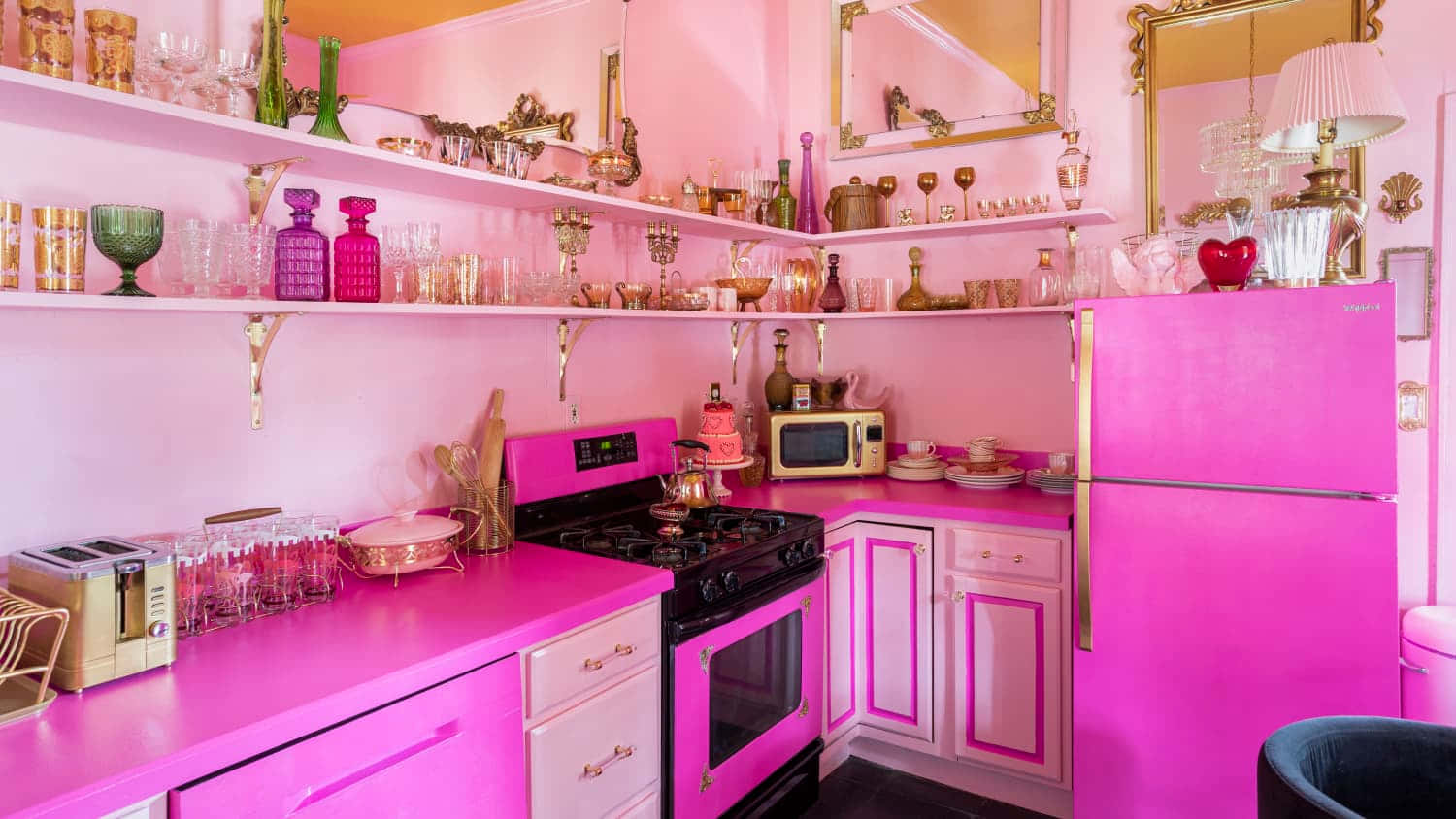 kitchen 桌布 壁紙 — 充滿活力的粉紅色廚房，配有復古電器和擺滿彩色玻璃器皿和復古裝飾的架子。