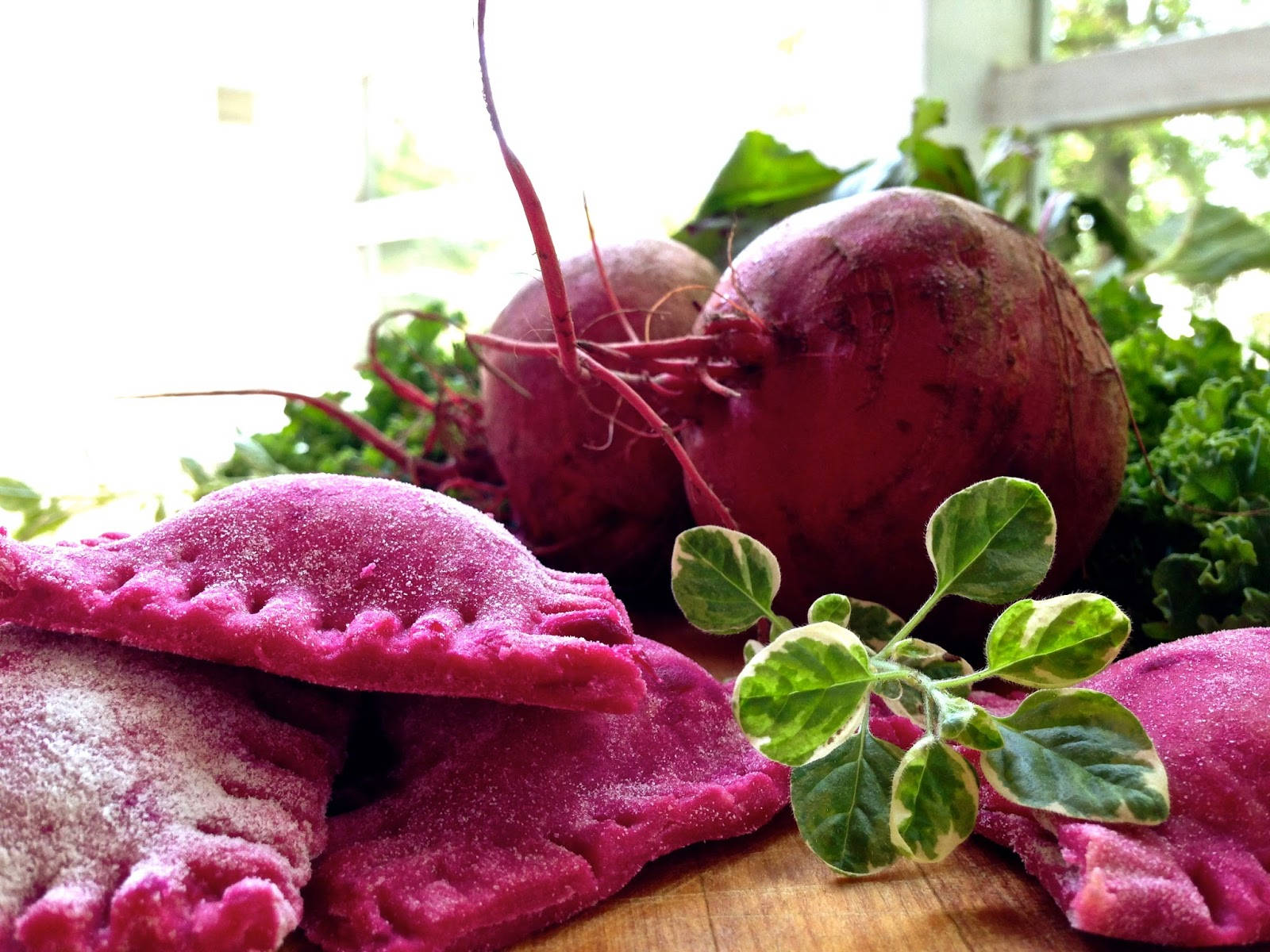 beetroot 桌布 壁紙 — 充滿活力的粉紅色甜菜根派撒上糖粉，放在木板上，旁邊是新鮮甜菜和綠葉。
