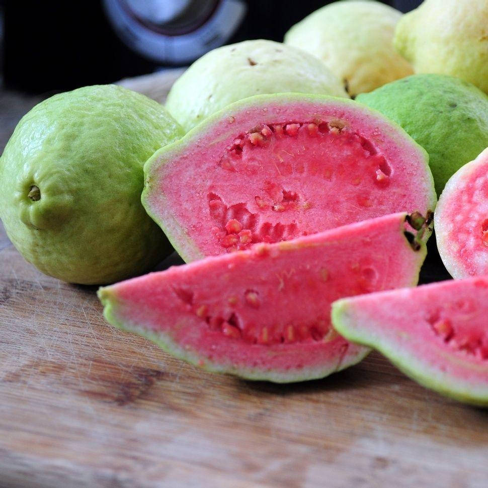 Fruit 桌布 壁紙 — 充滿活力的粉紅色番石榴果肉與鄉村風格木砧板上的綠色果皮形成對比。