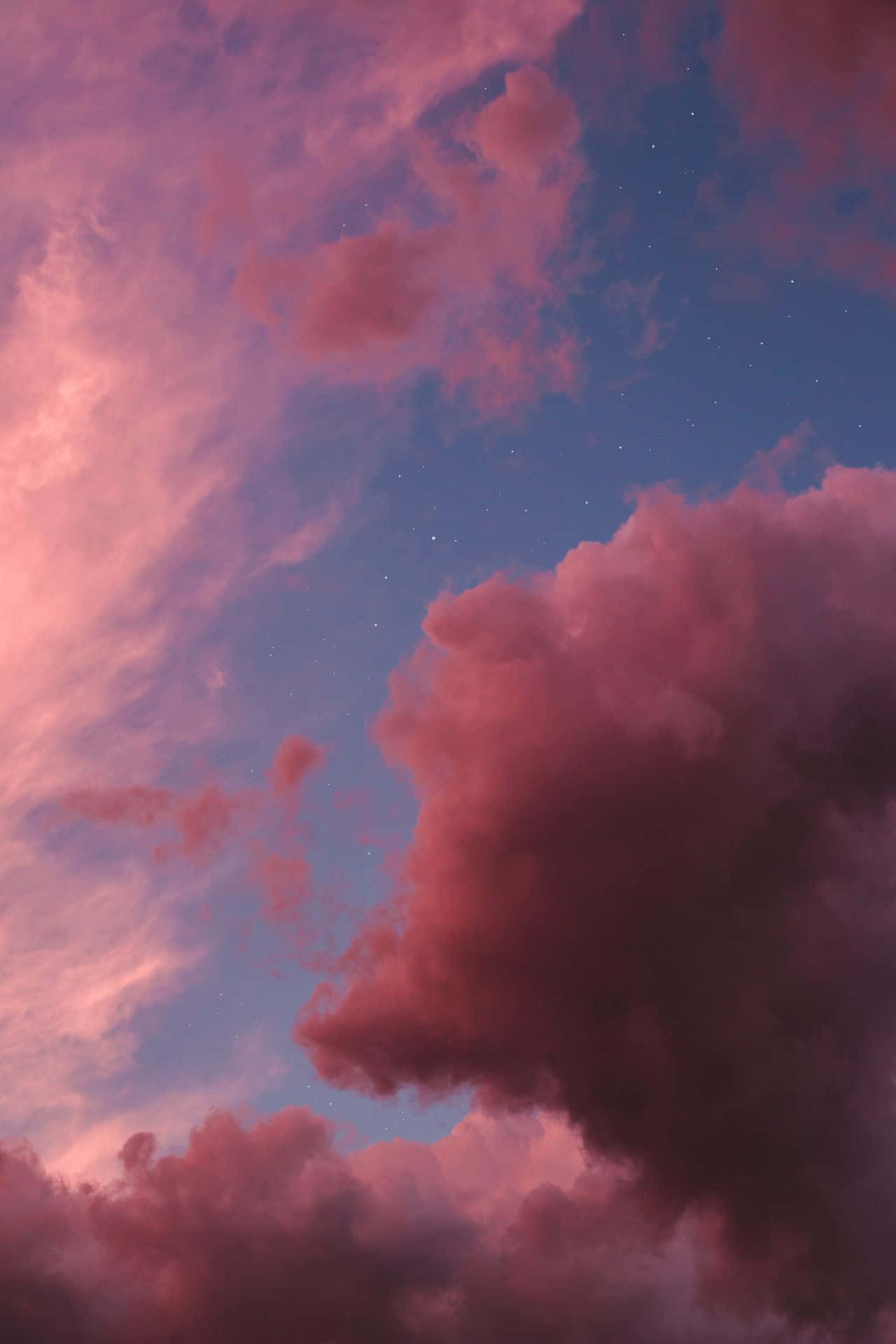 Aesthetic Sky 桌布 壁紙 — 充滿活力的粉紅色雲朵飄過點綴著可見星星的暮色天空，營造出夢幻般的天體場景。