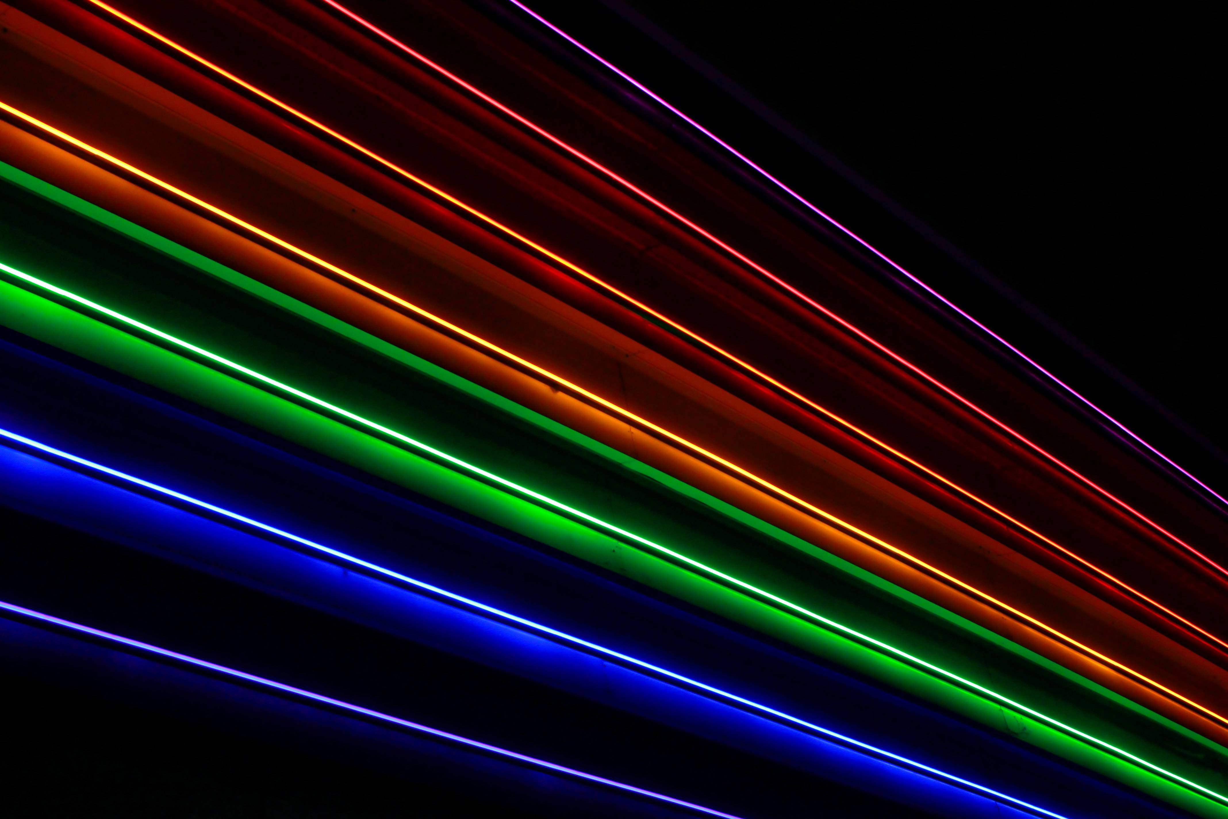 Stripes 桌布 壁紙 — 充滿活力的紅、綠、藍、紫霓虹光斜紋在漆黑背景上閃耀。