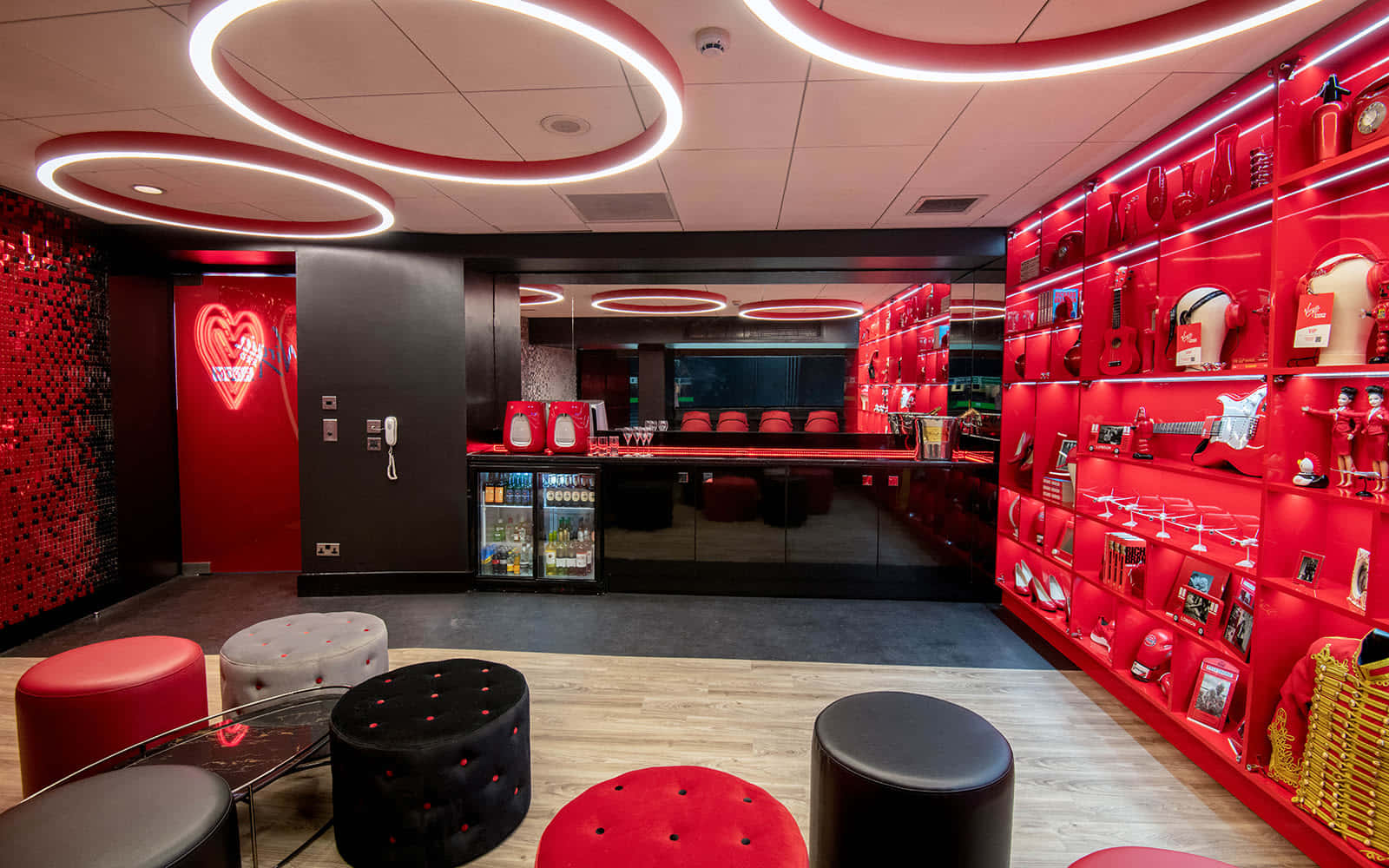 Red Room 桌布 壁紙 — 充滿活力的紅色主題休息室，配有圓形天花板燈和展示吉他及紀念品的架子。