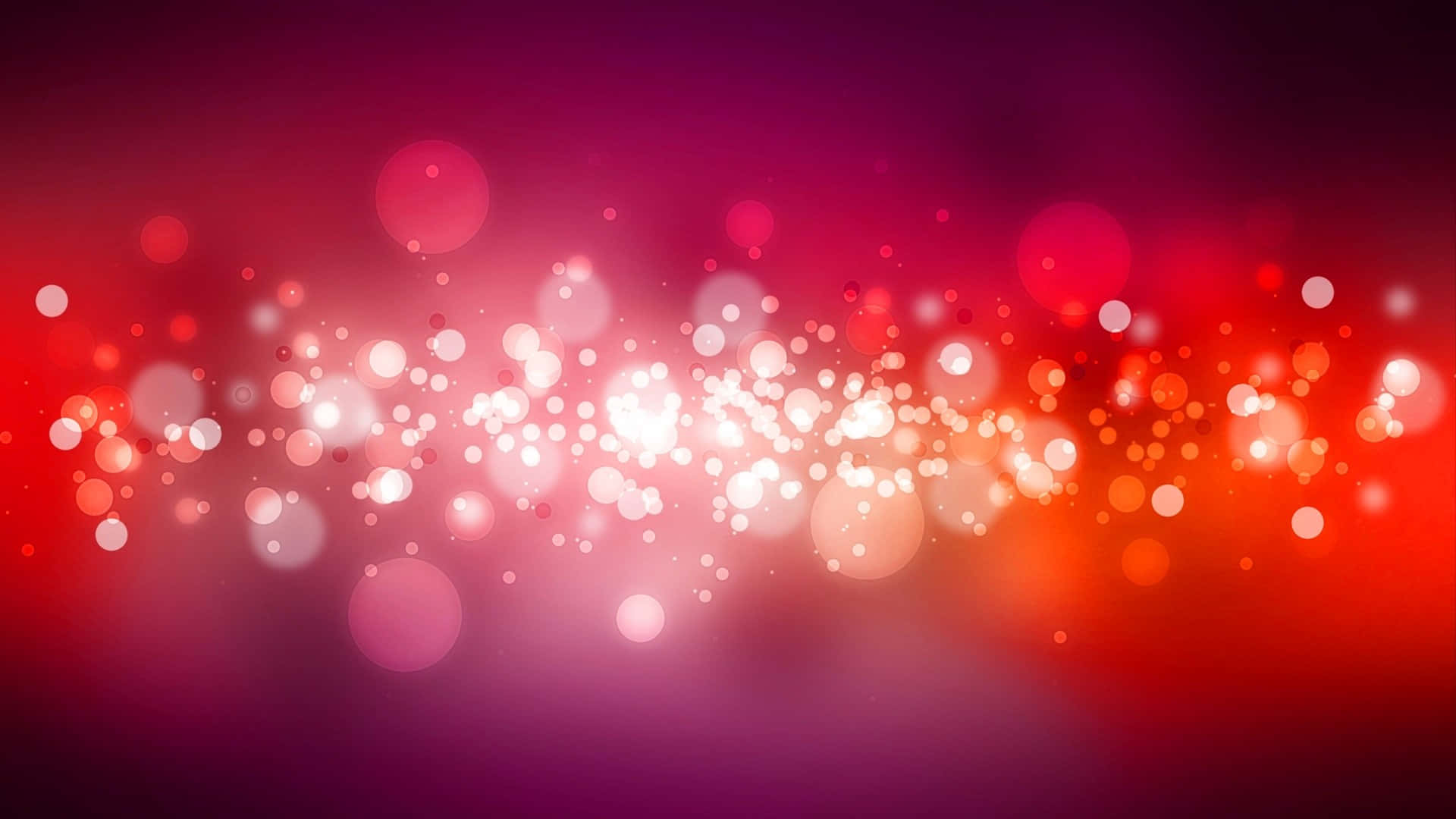 Bubbles 桌布 壁紙 — 充滿活力的紅色和粉紅色漸變背景，帶有發光的散景燈光，營造出節日而充滿活力的氛圍。