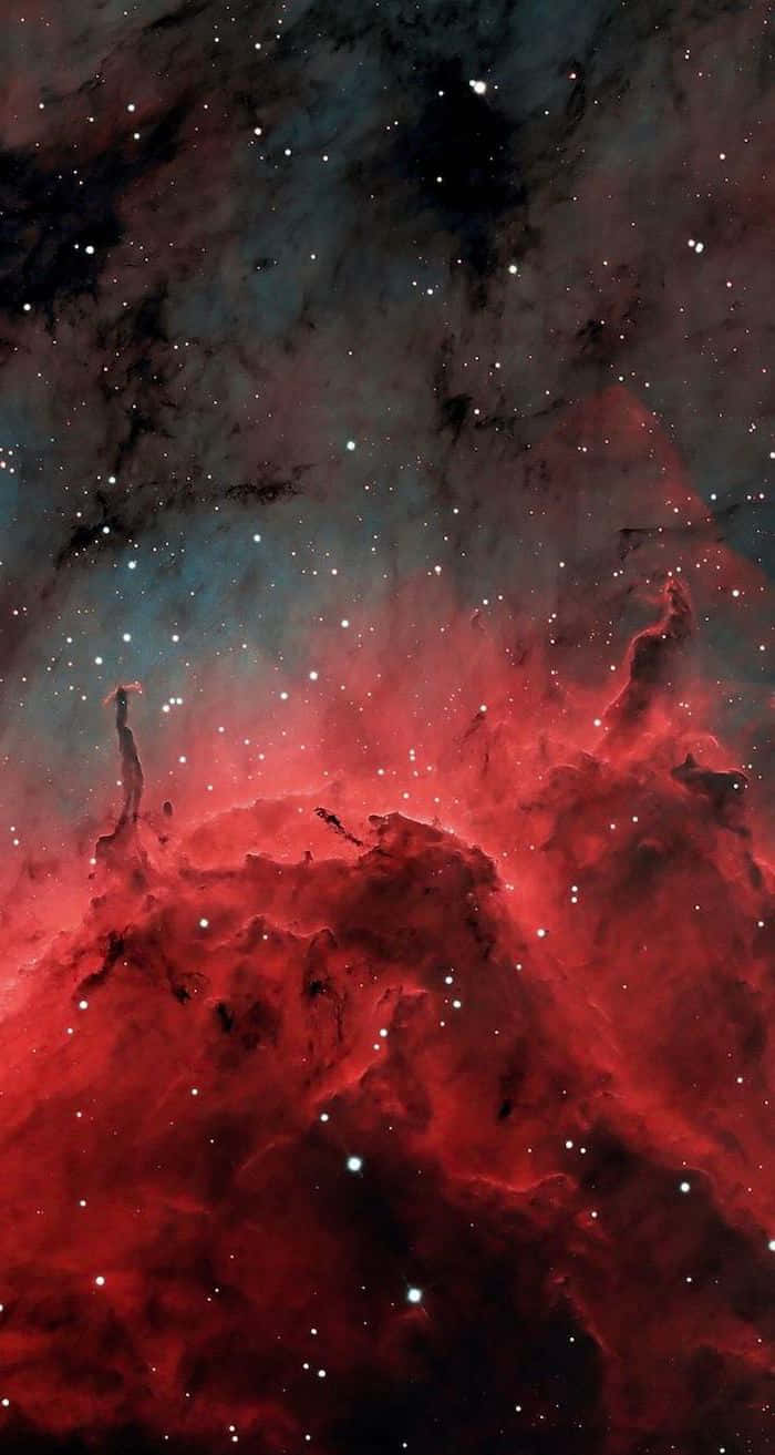 Red Galaxy 桌布 壁紙 — 充滿活力的紅色宇宙雲層在閃爍的星群中旋轉，形成戲劇性的深空星雲。