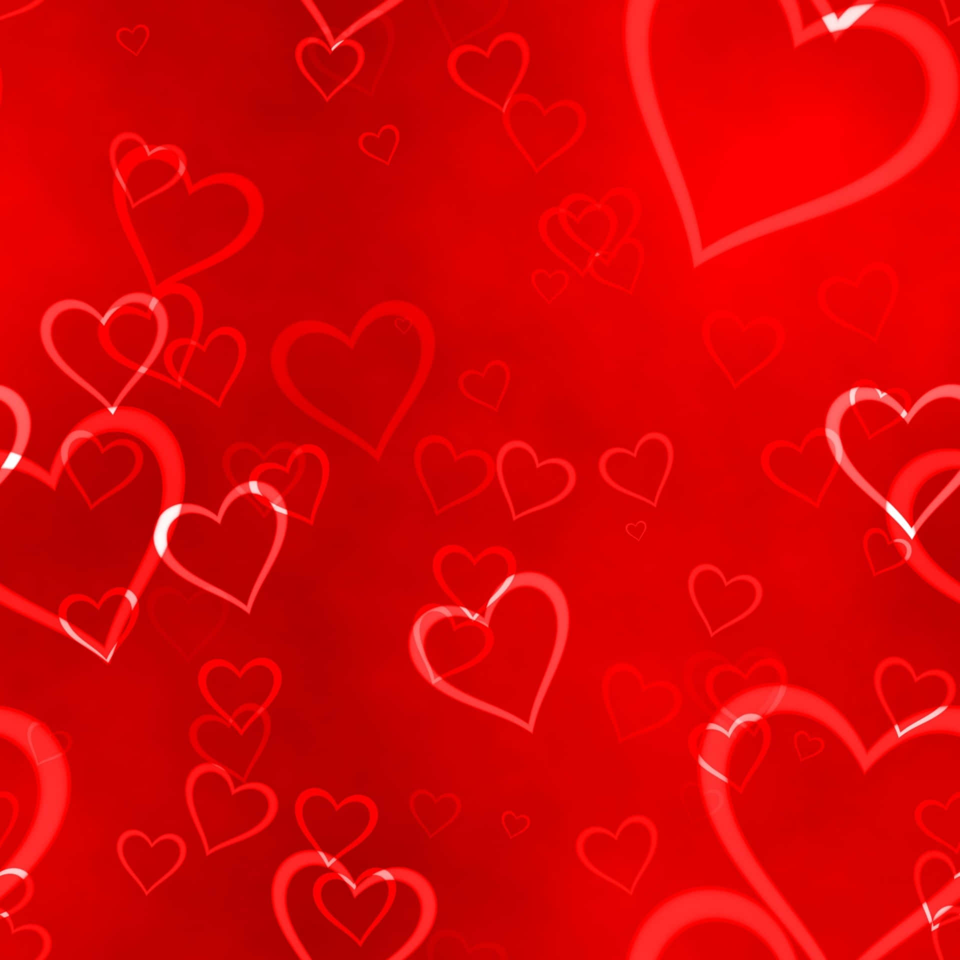 Red Heart 桌布 壁紙 — 充滿活力的紅色背景，點綴著大小不一、發光的半透明心形輪廓，漂浮成浪漫的圖案。