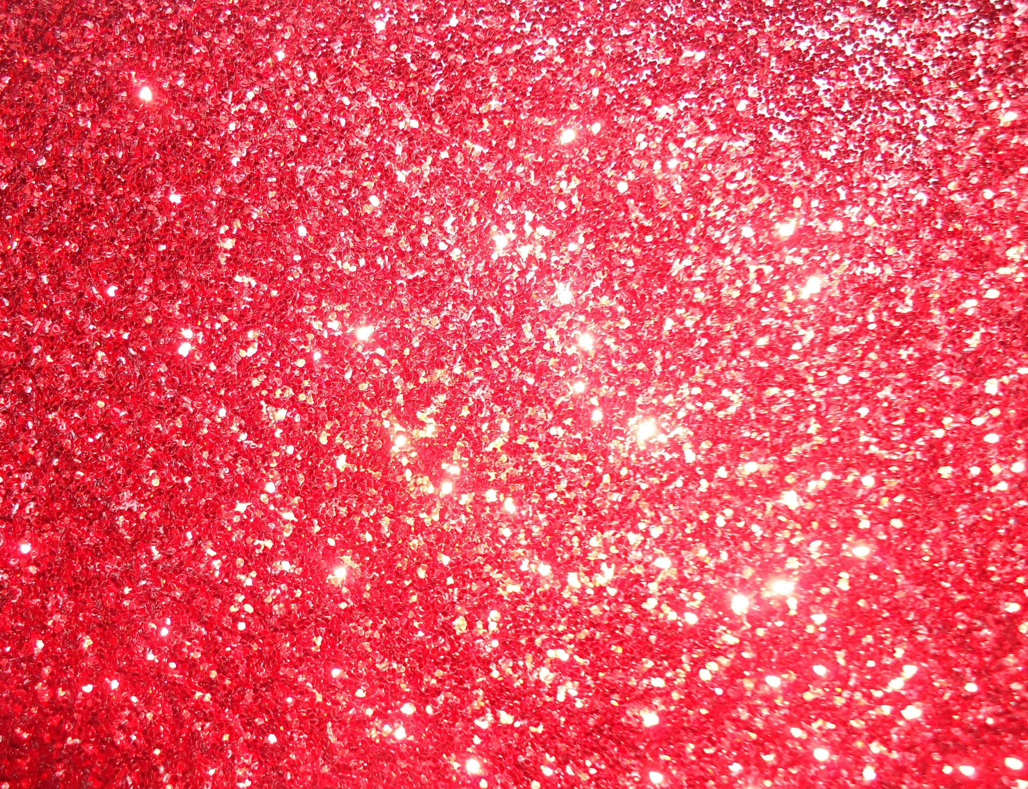 Red Glitter 桌布 壁紙 — 充滿活力的紅色閃粉質感，帶有閃爍的金色斑點，在光線下形成密集閃爍的圖案。