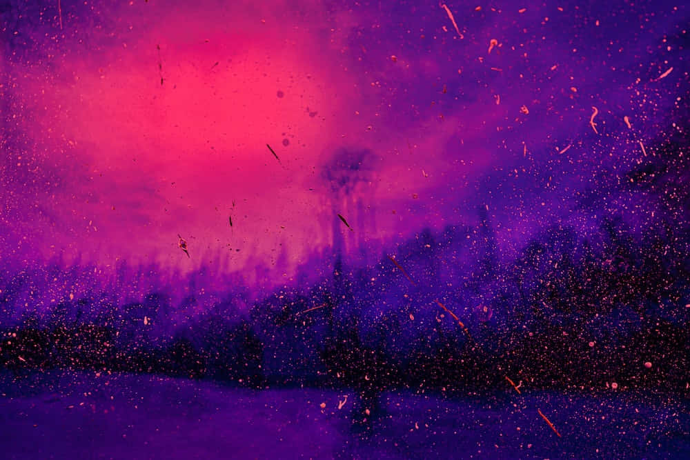 Aesthetic Purple 桌布 壁紙 — 充滿活力的紫色和粉紅色宇宙天空，帶有發光粒子及下方深色剪影樹木。