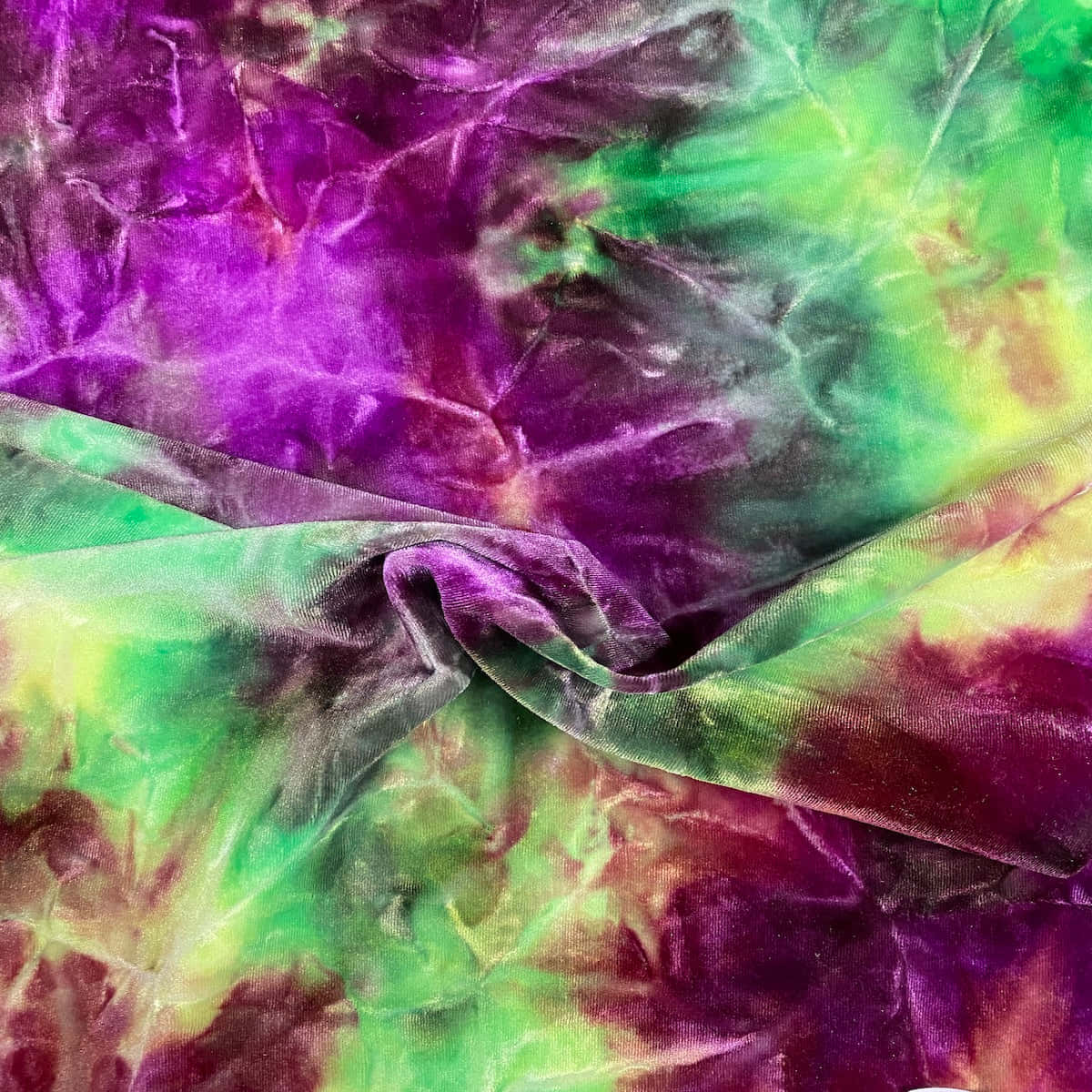 Purple Tie Dye 桌布 壁紙 — 充滿活力的紫色和綠色紮染布料，帶有皺褶紋理和柔軟摺痕。