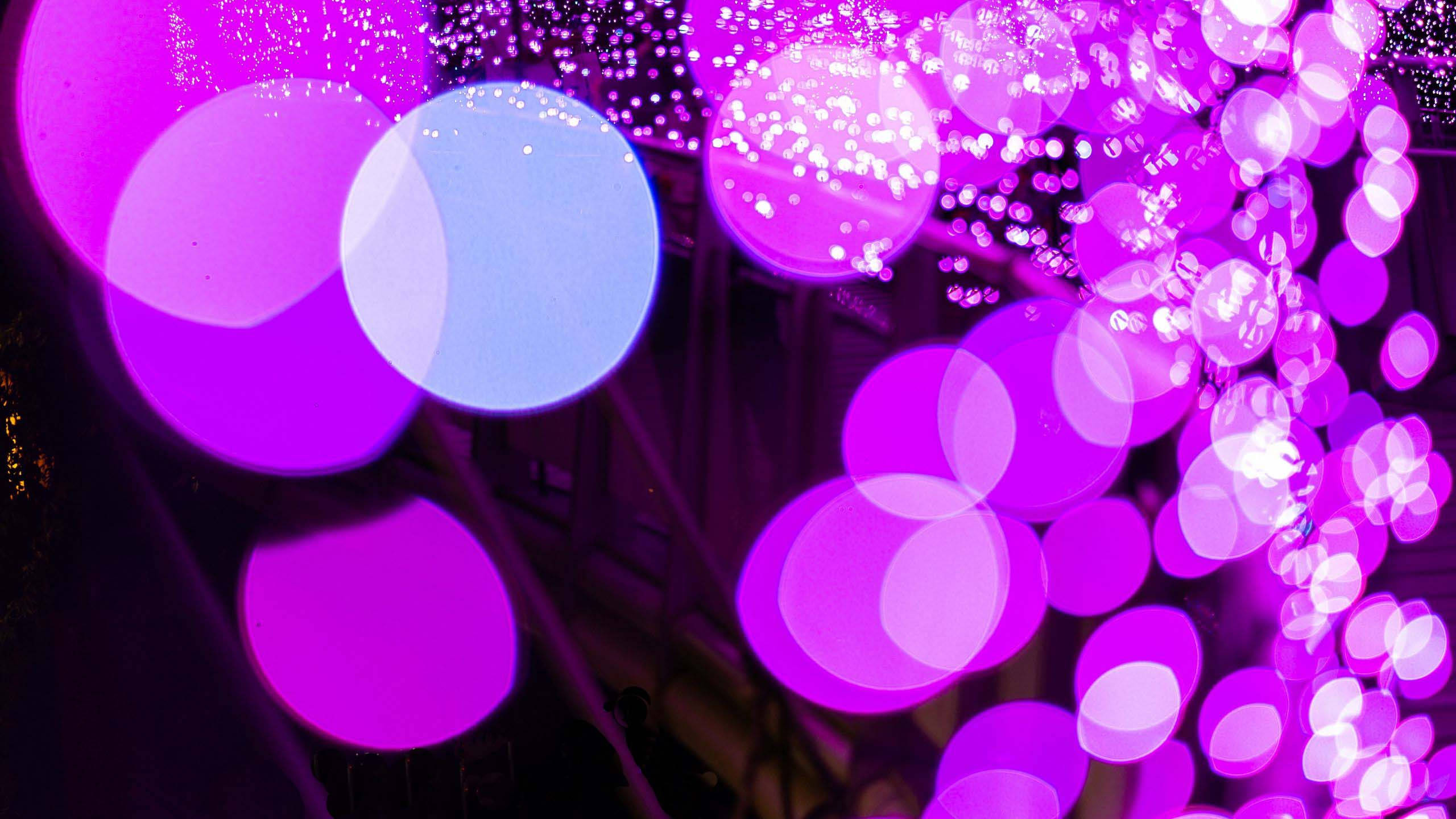 Violet Aesthetic 桌布 壁紙 — 充滿活力的紫色和藍色散景燈光在黑暗背景下閃爍出耀眼的抽象圖案。