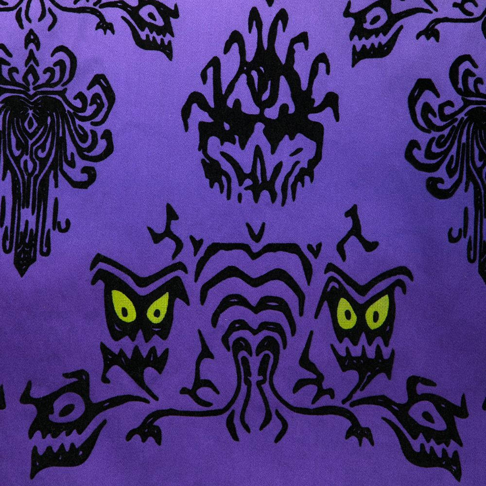 haunted 桌布 壁紙 — 充滿活力的紫色布料，飾以大膽的黑色部落骷髏頭和發光的綠色眼睛，形成重複的萬聖節圖案。