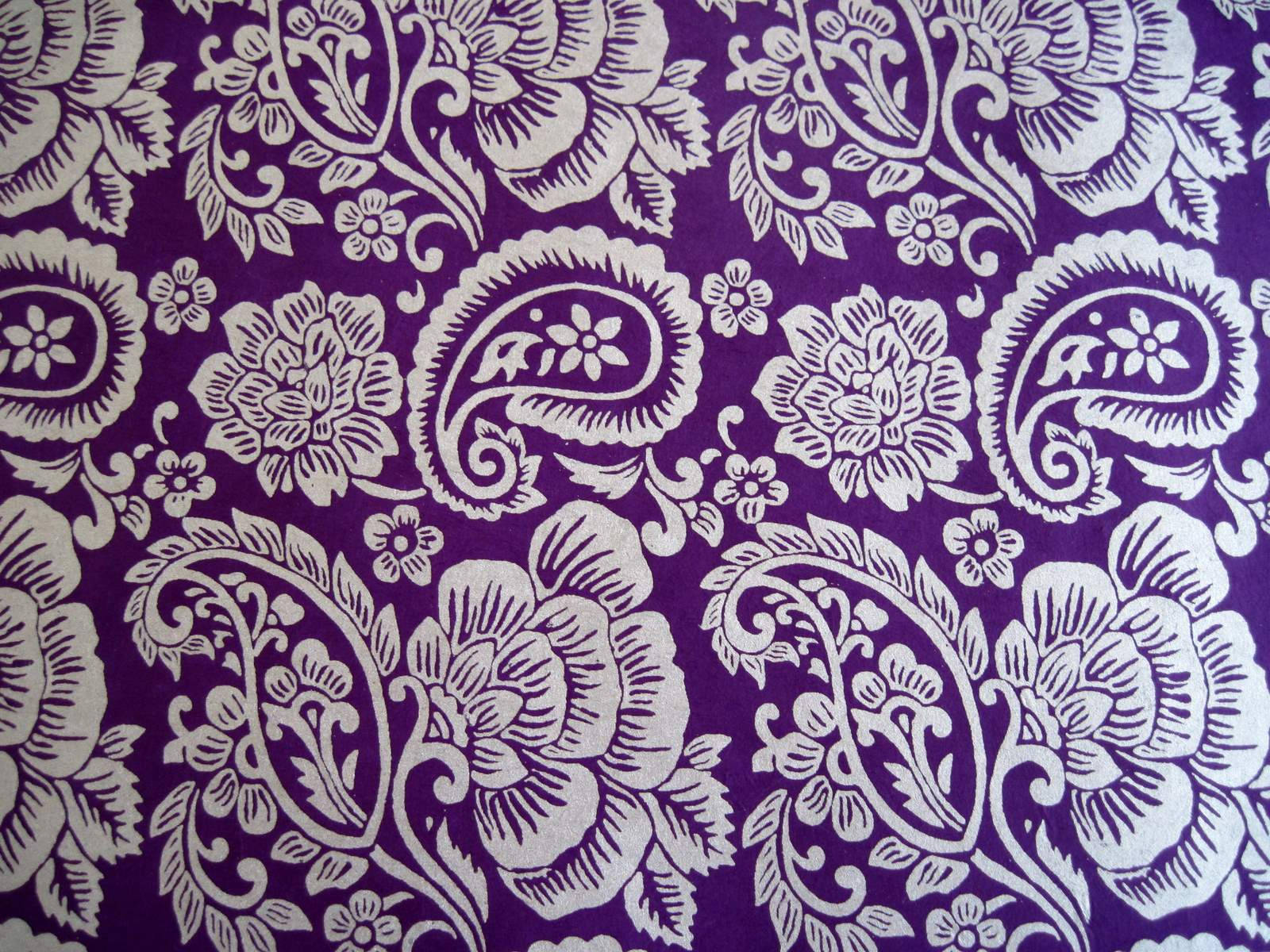 Paisley 桌布 壁紙 — 充滿活力的紫色布料，飾有複雜的白色佩斯利和花卉圖案，重複的裝飾設計。