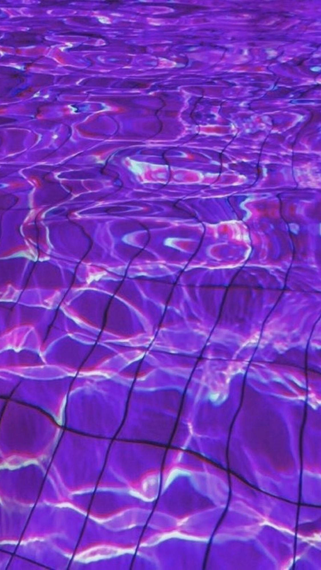 Kawaii Purple 桌布 壁紙 — 充滿活力的紫色水波紋在磁磚泳池地板上閃爍著電燈反射的光芒。